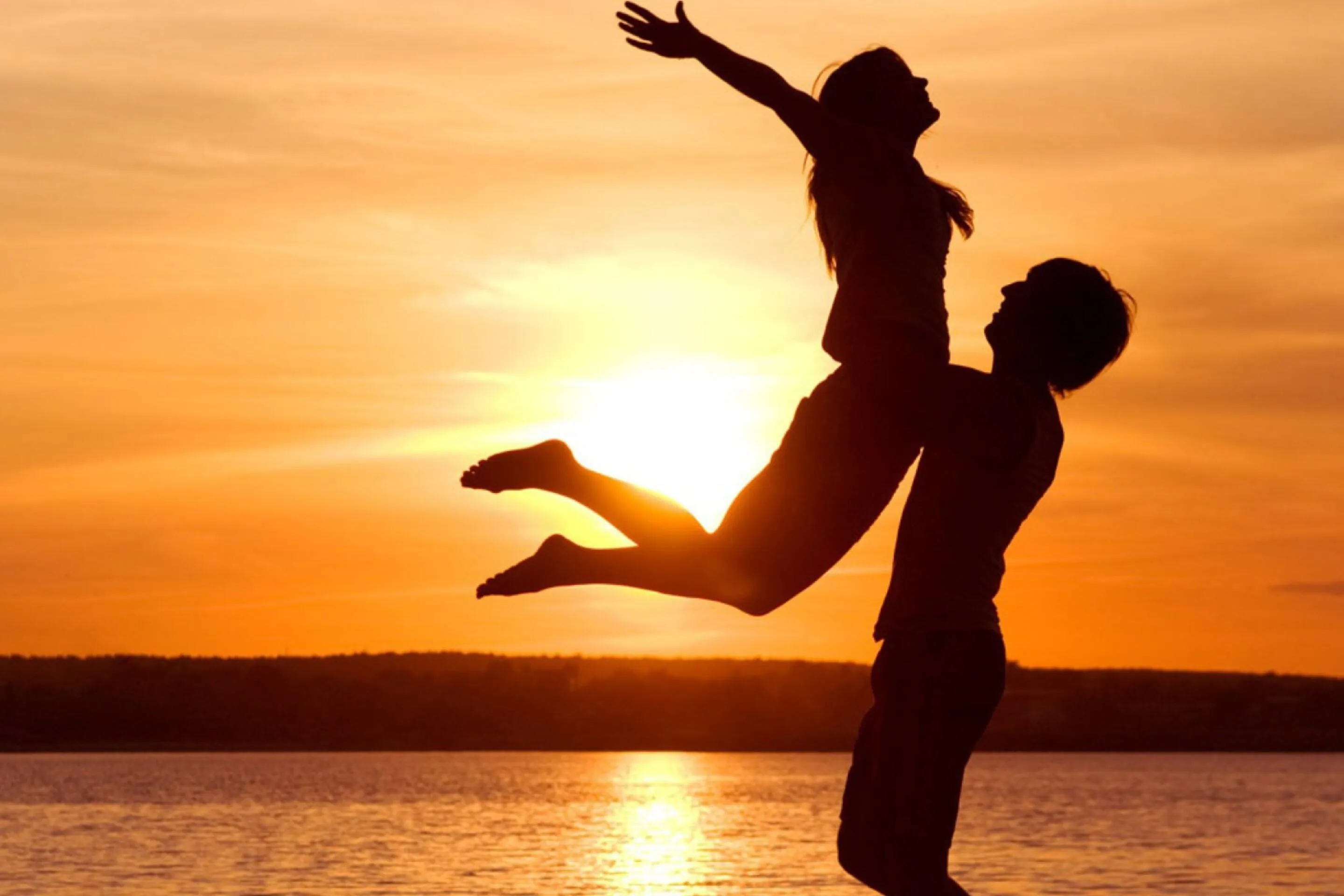 Couple Jumping with Joy in Sunset Light Moment Wallpaper