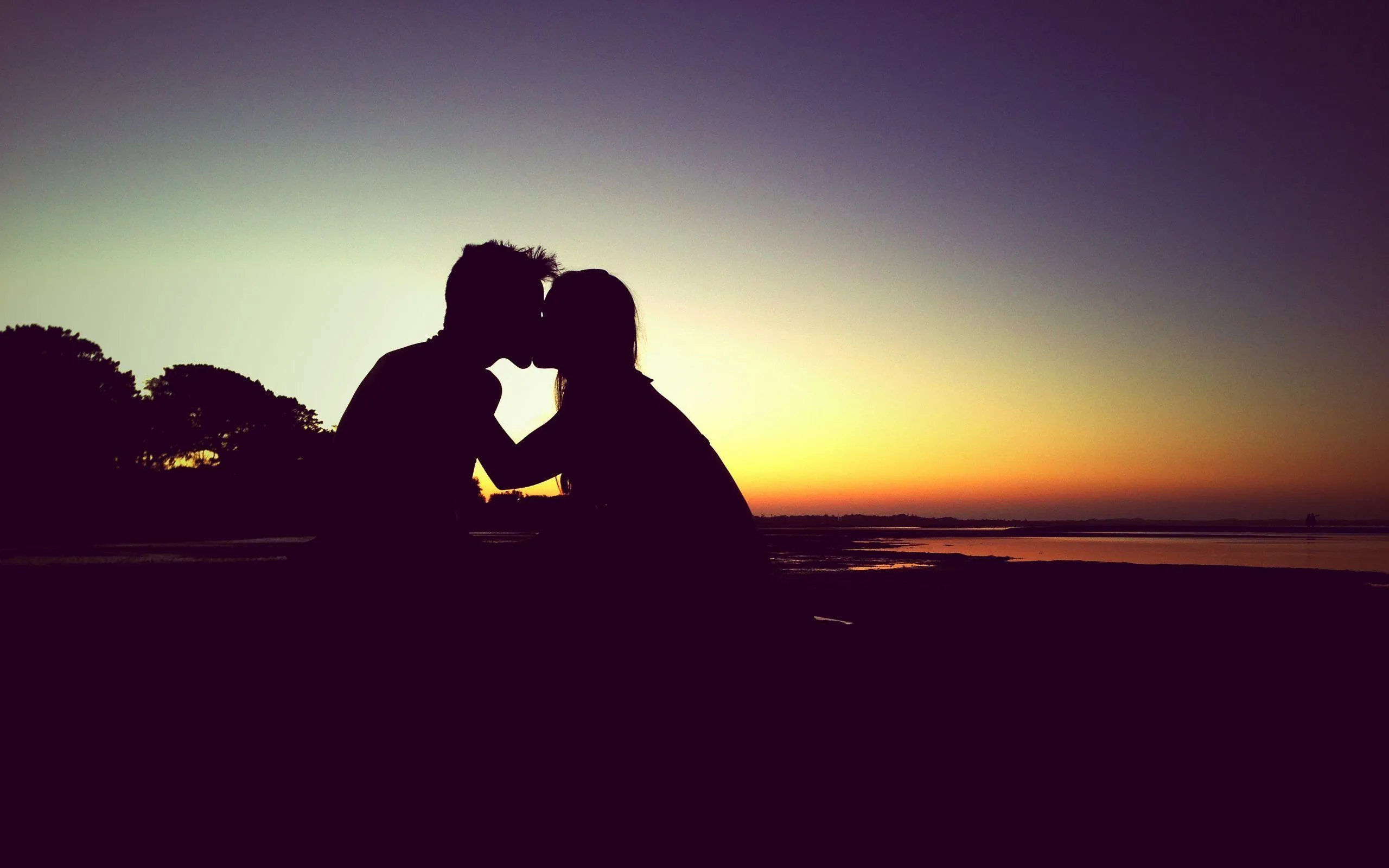 Couple Kissing at Sunset Sharing Intimate Moment HD Image