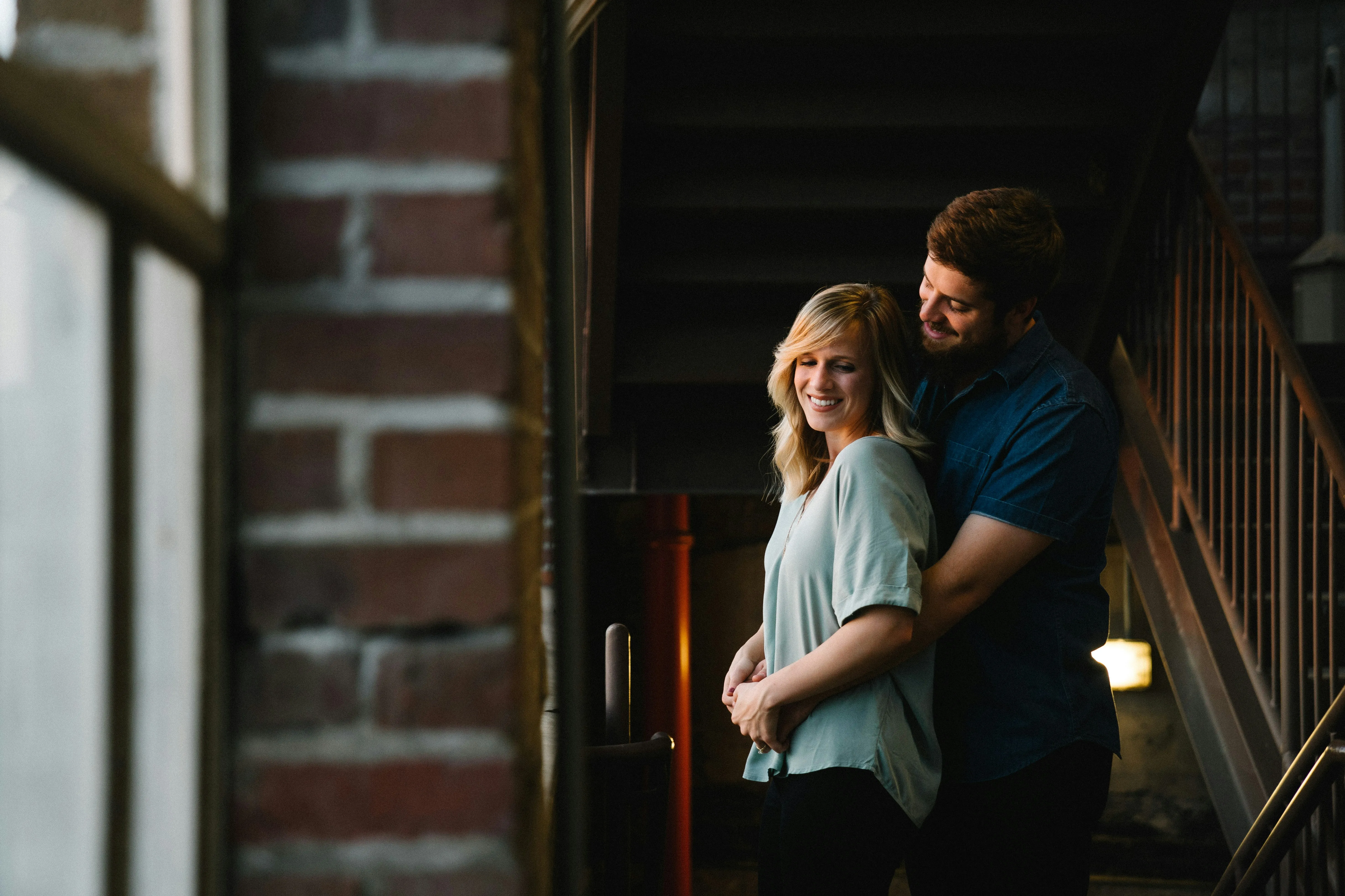 Couple Sharing Tender Moment Near Brick Wall Wallpaper