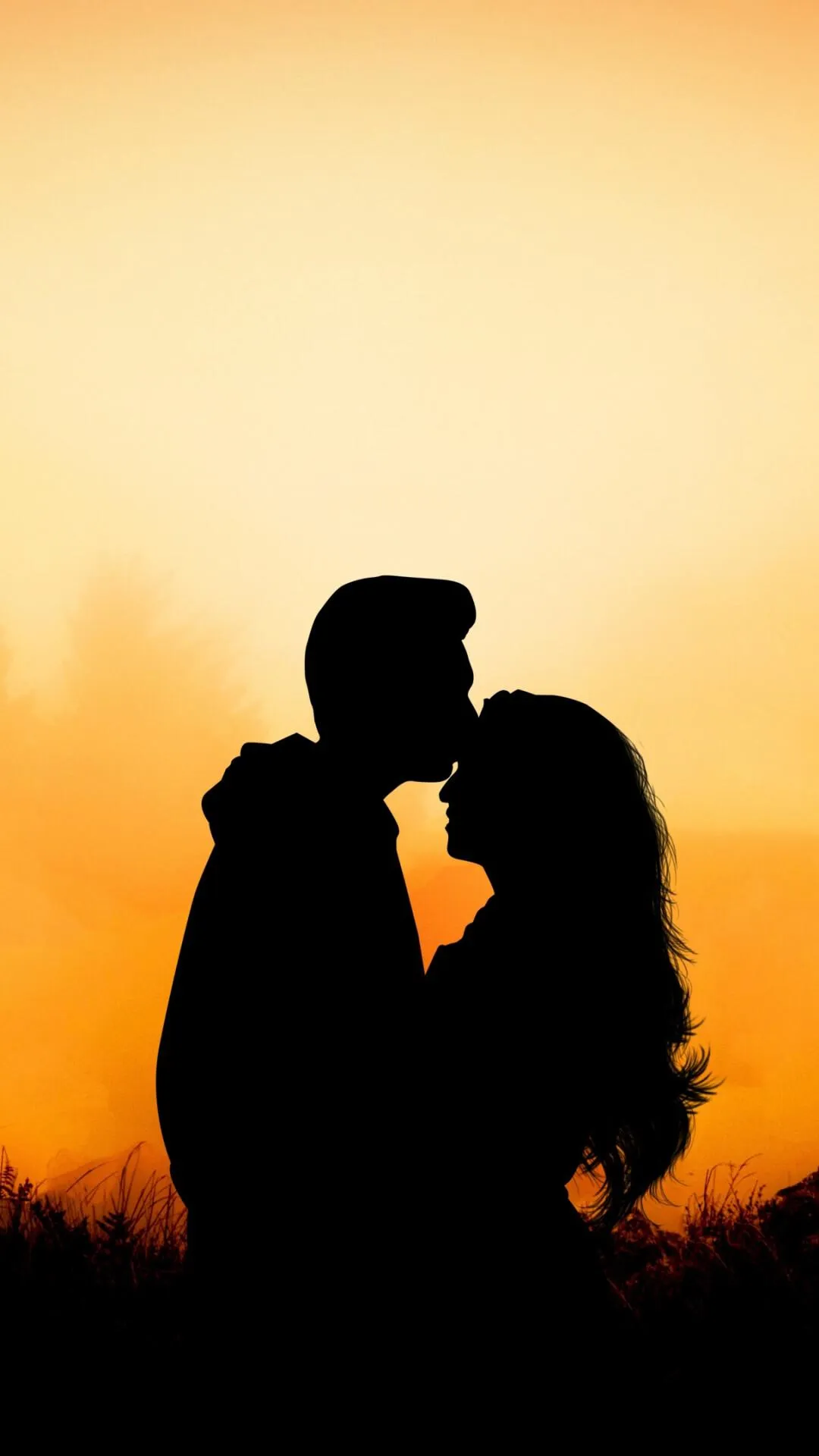 Couple Silhouette Holding Each Other at Sunset Wallpaper