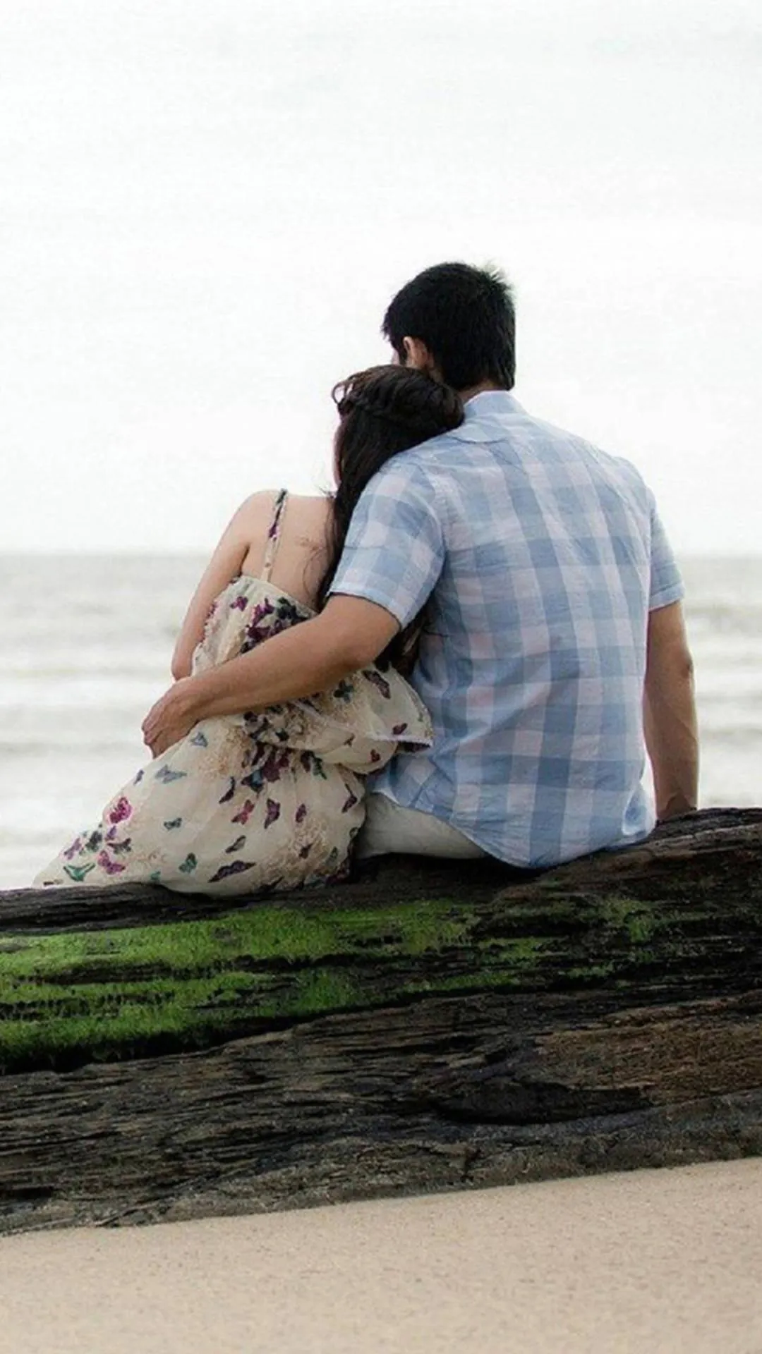 Couple Sitting by Sea Sharing Moment of Connection