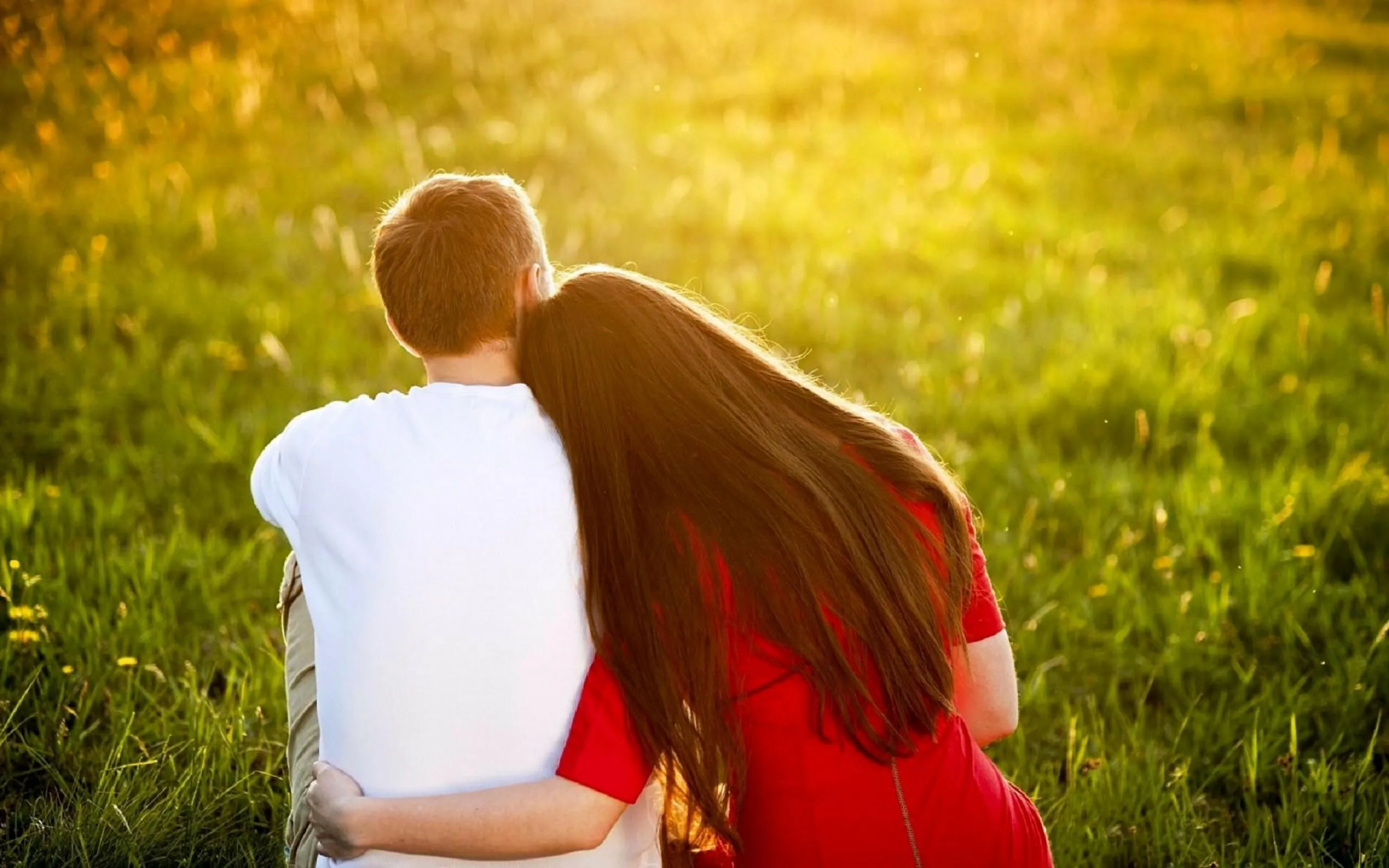 Couple Sitting in Sunset Field with Endless Romance