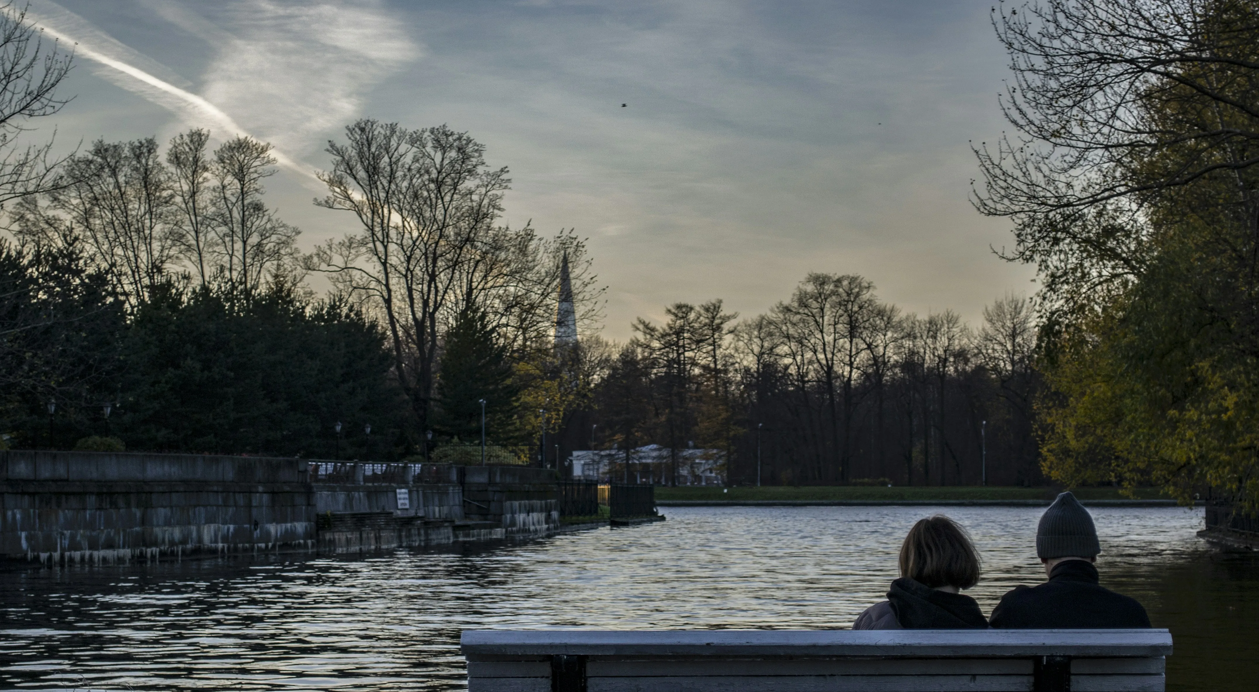 Couple Sitting Peacefully by the Lake at Evening Time
