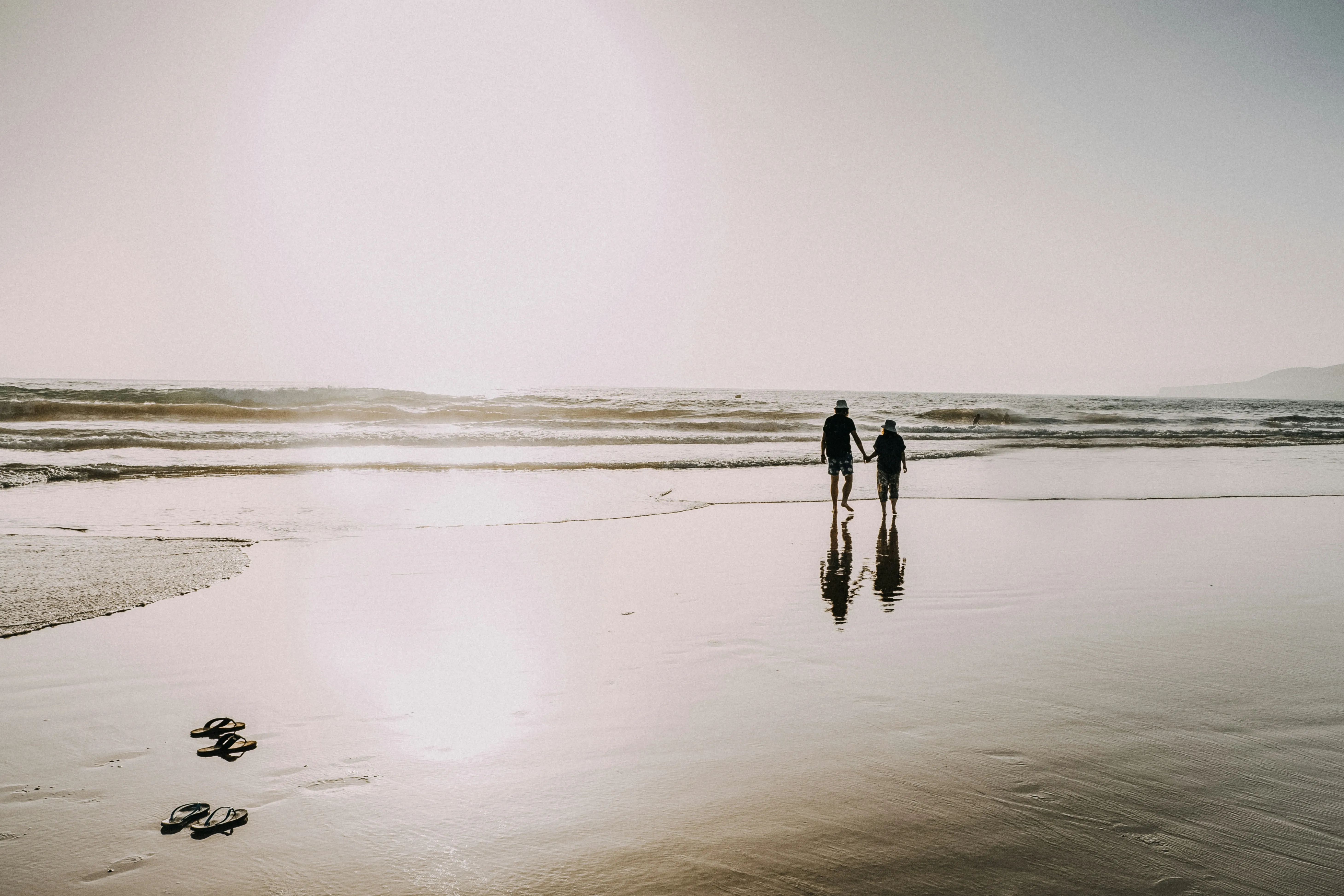 Couple Walking on Beach Sharing Peaceful Moments Wallpaper