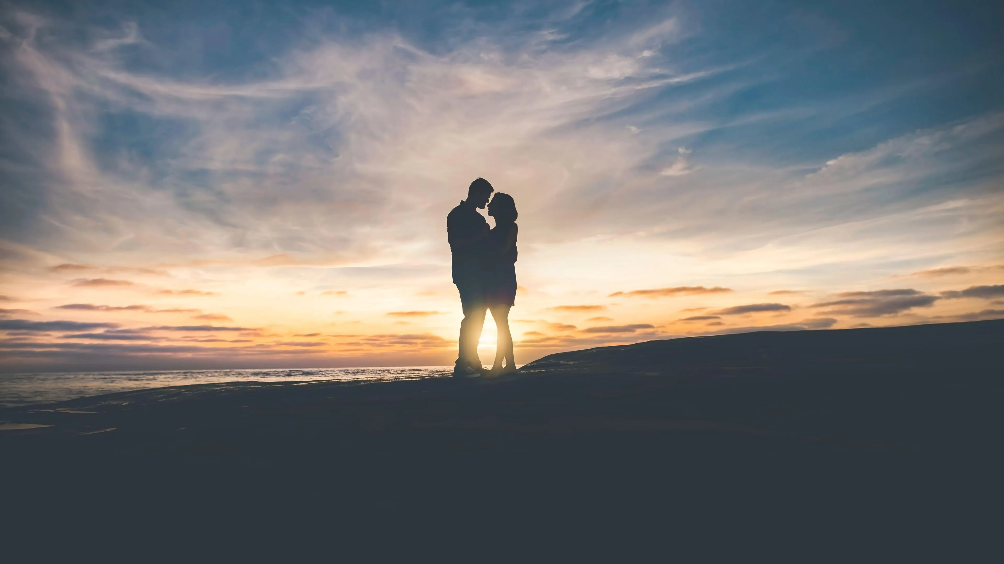 Couple Walking on Beach Together at Beautiful Sunset
