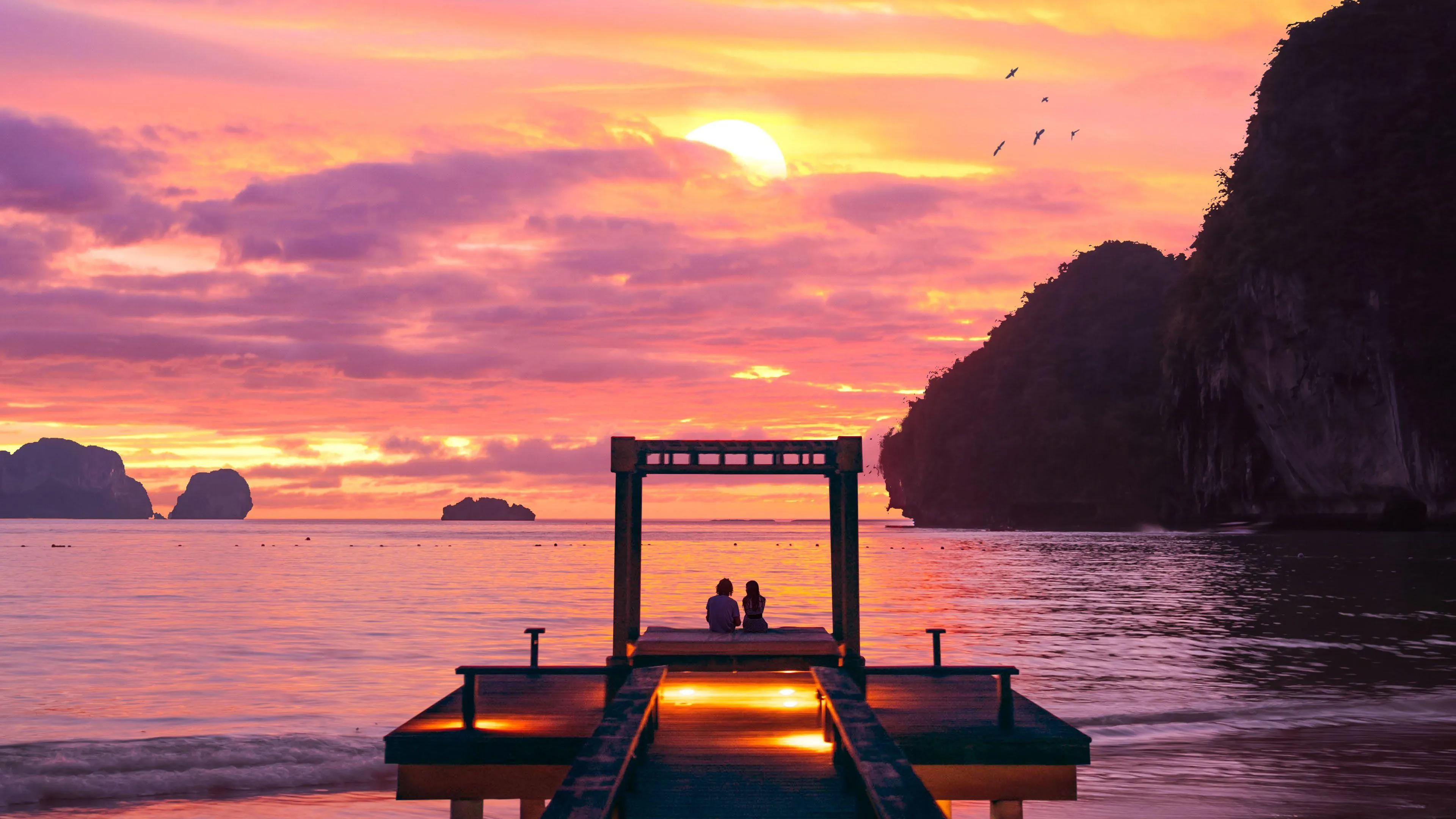 Couple Watching a Beautiful Sunset on the Pier at Dusk
