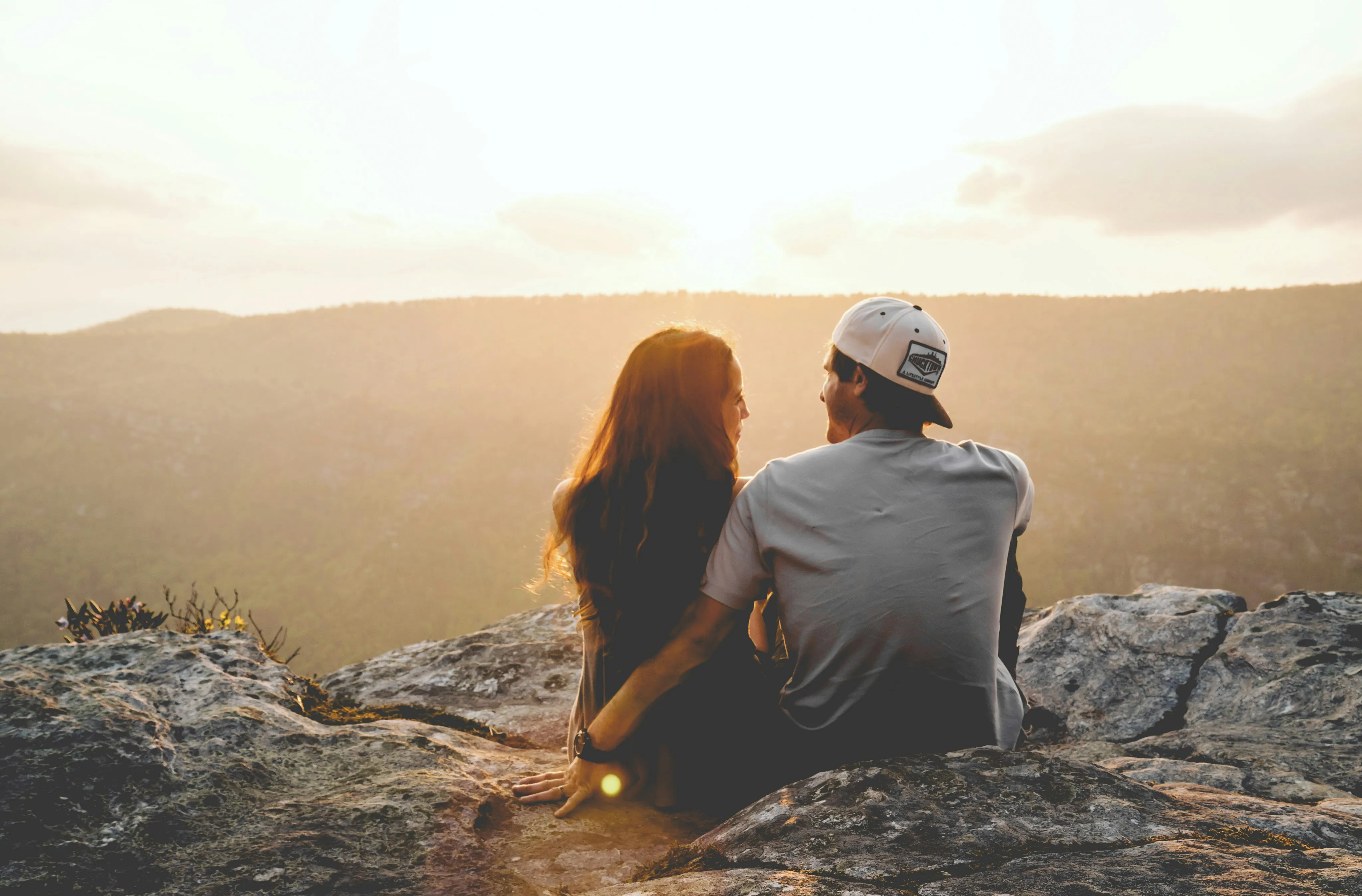 Couple Watching Sunset Portraying True Companionship Wallpaper