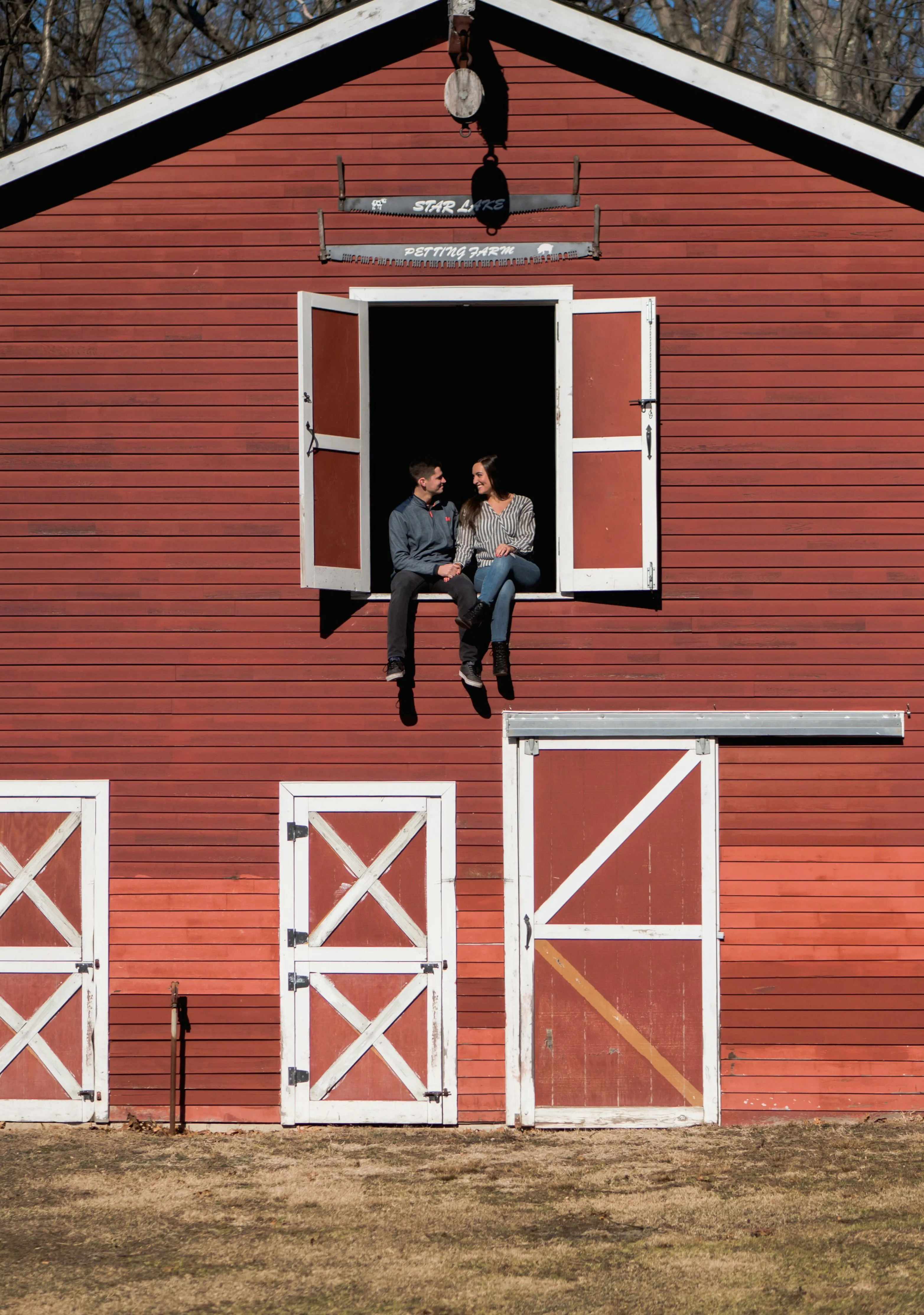 Couples in Red Barn with White Trim in Peaceful Countryside