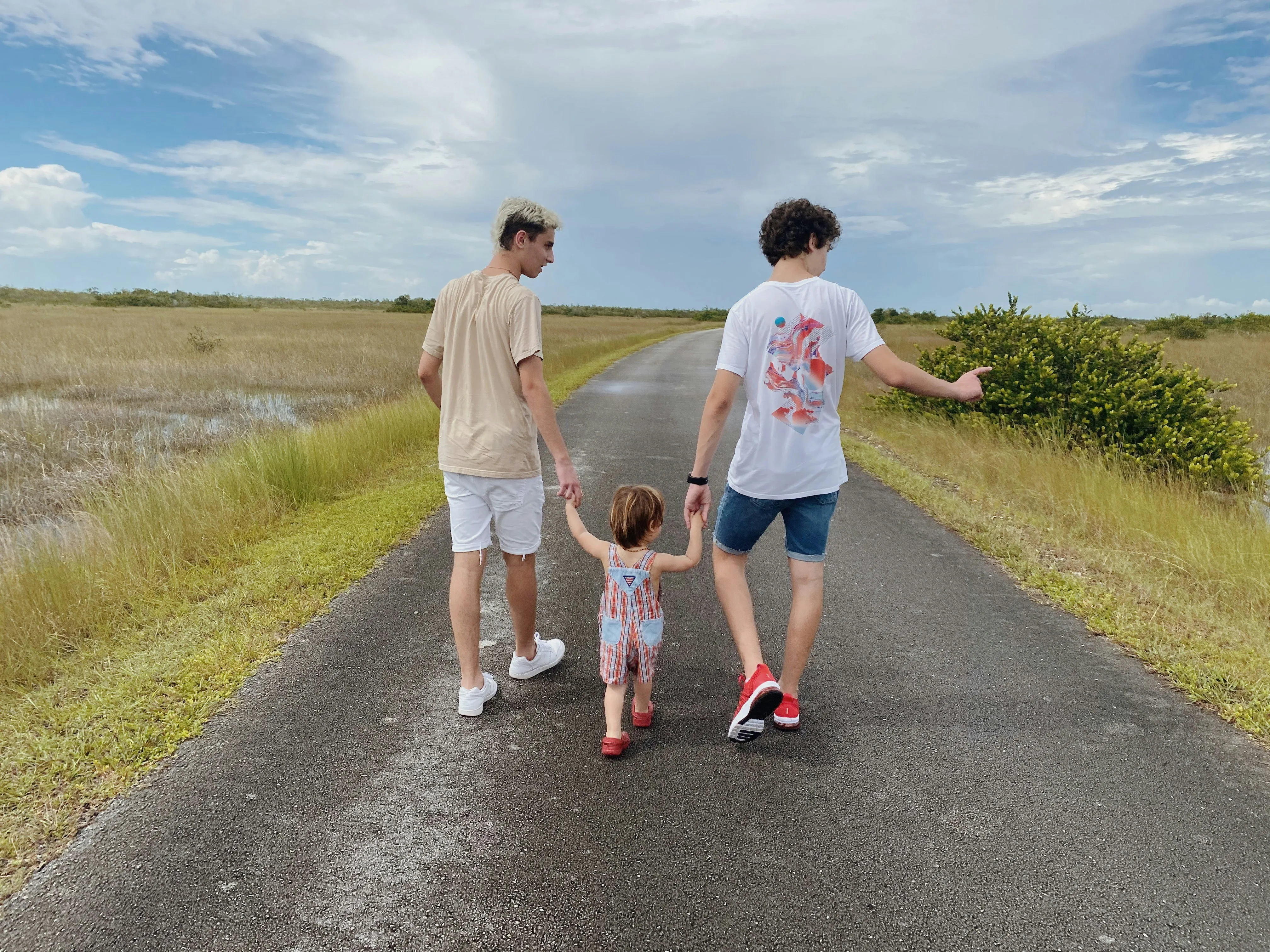 Family Walking Down Road Together in Evening Light