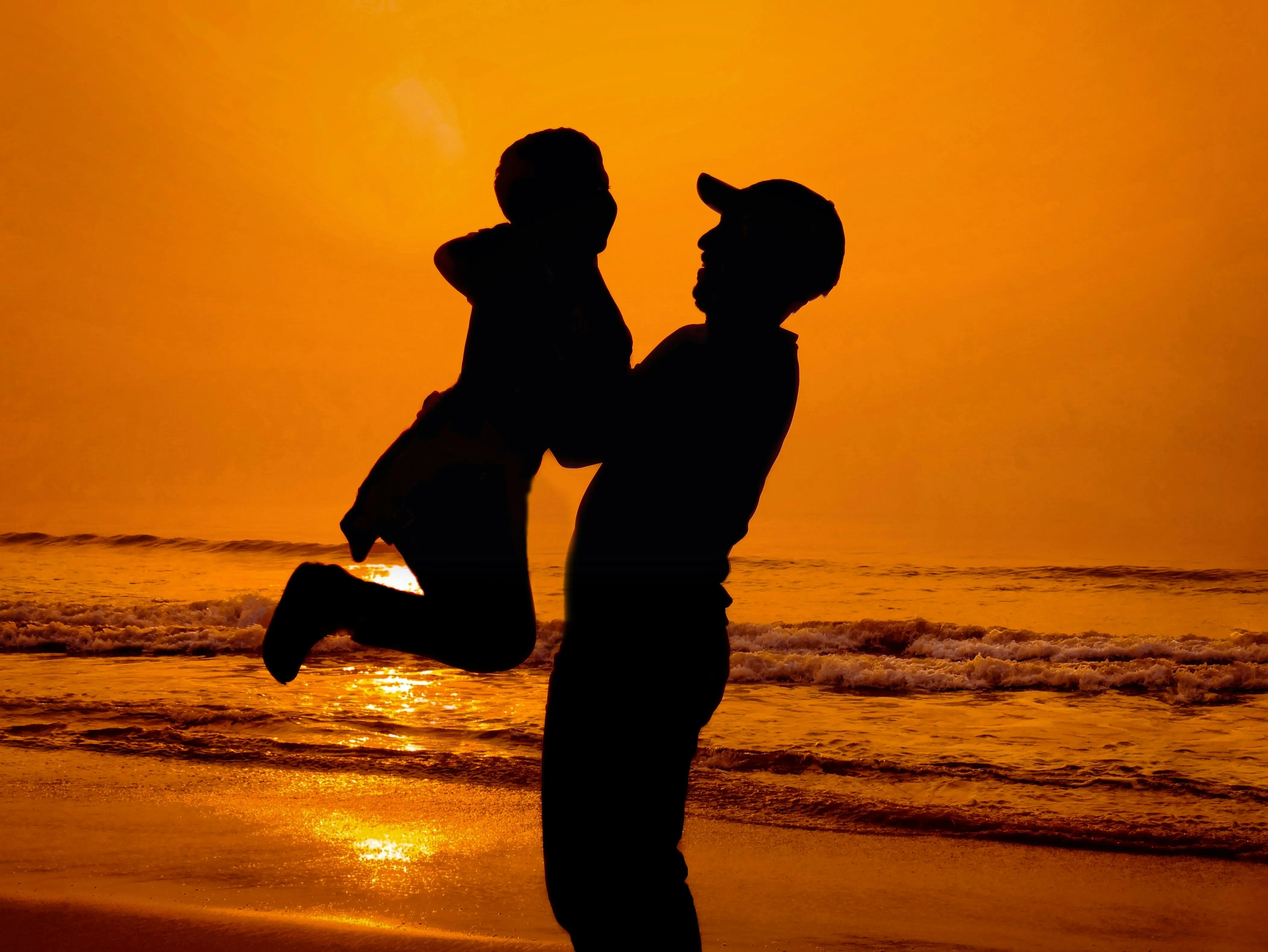 Father and Son Embracing Joyfully on the Sunset Beach