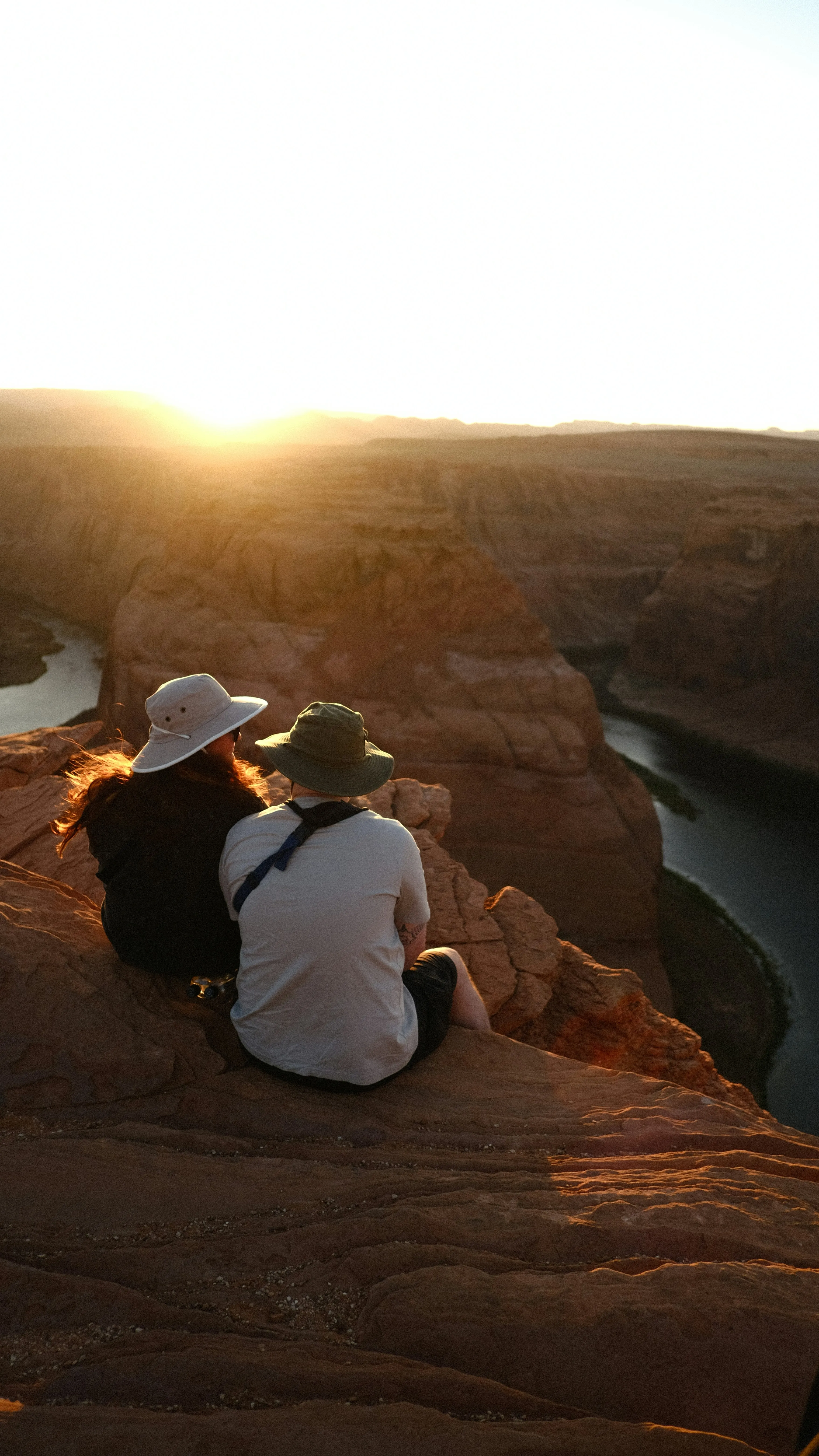 Friends Sitting on Hill Watching Golden Sunset Wallpaper