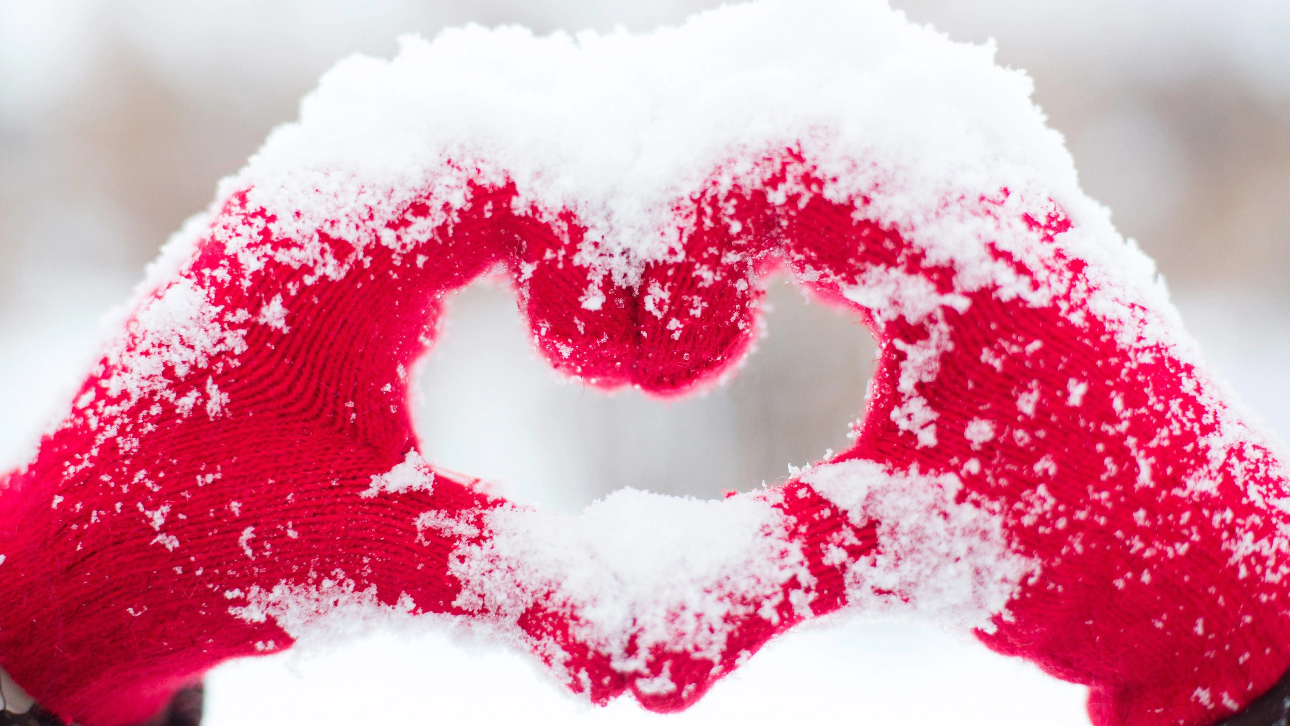 Hands Forming Heart Shape in Bright White Snow Wallpaper