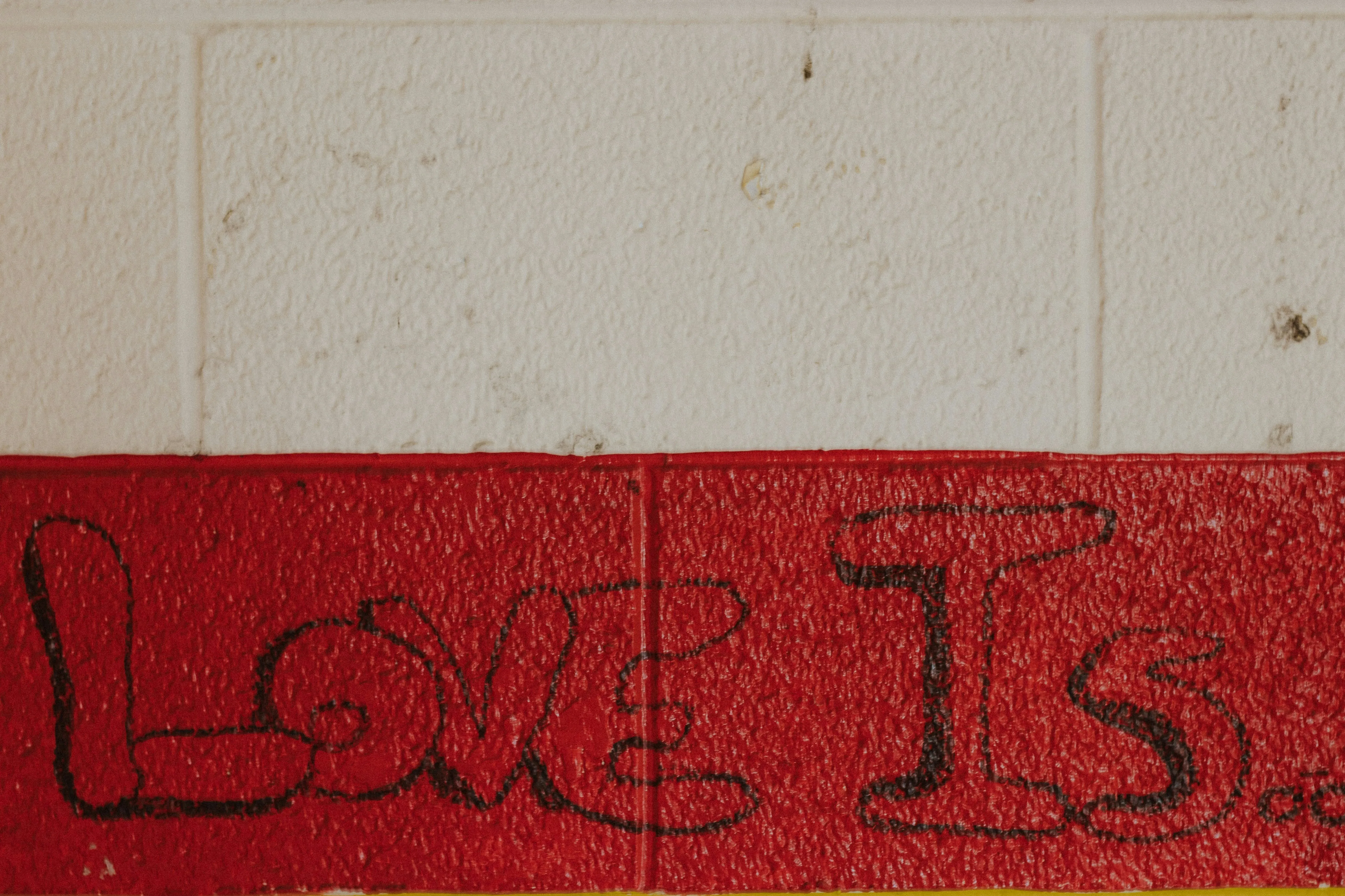 Love Is Text Painted on Red Wall in Urban Setting Wallpaper