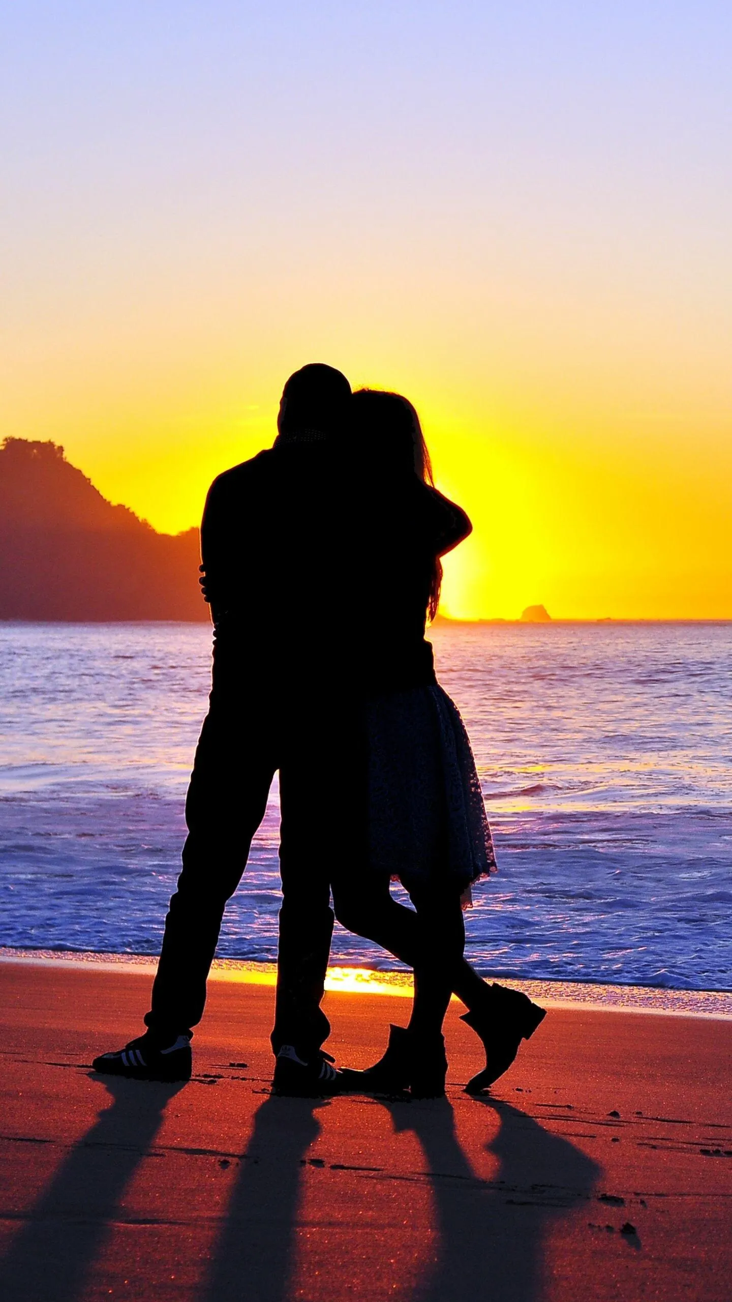 Lovers Embracing Sunset on Peaceful Seashore Wallpaper