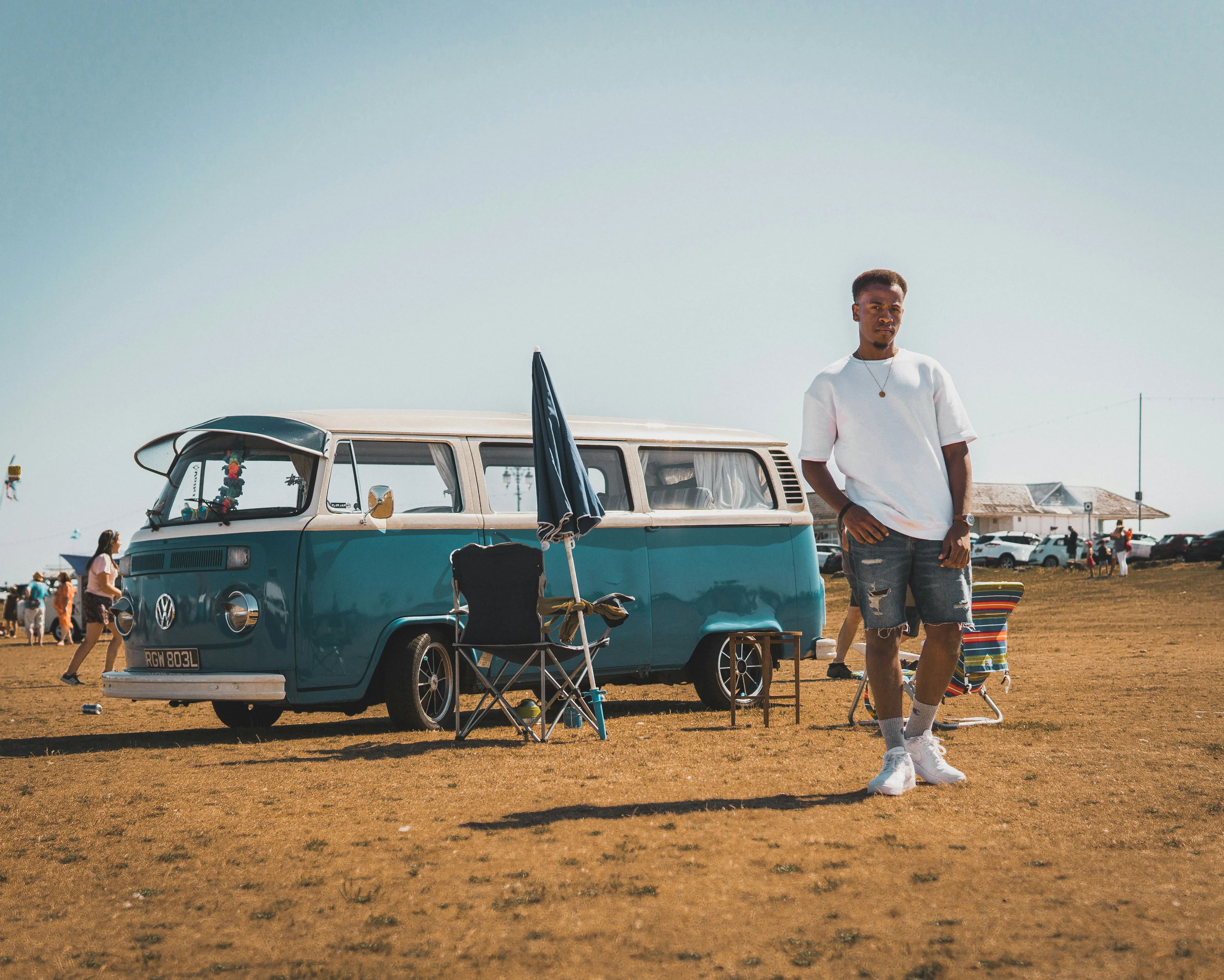 Man Standing Beside Vintage Car in Warm Desert Sun
