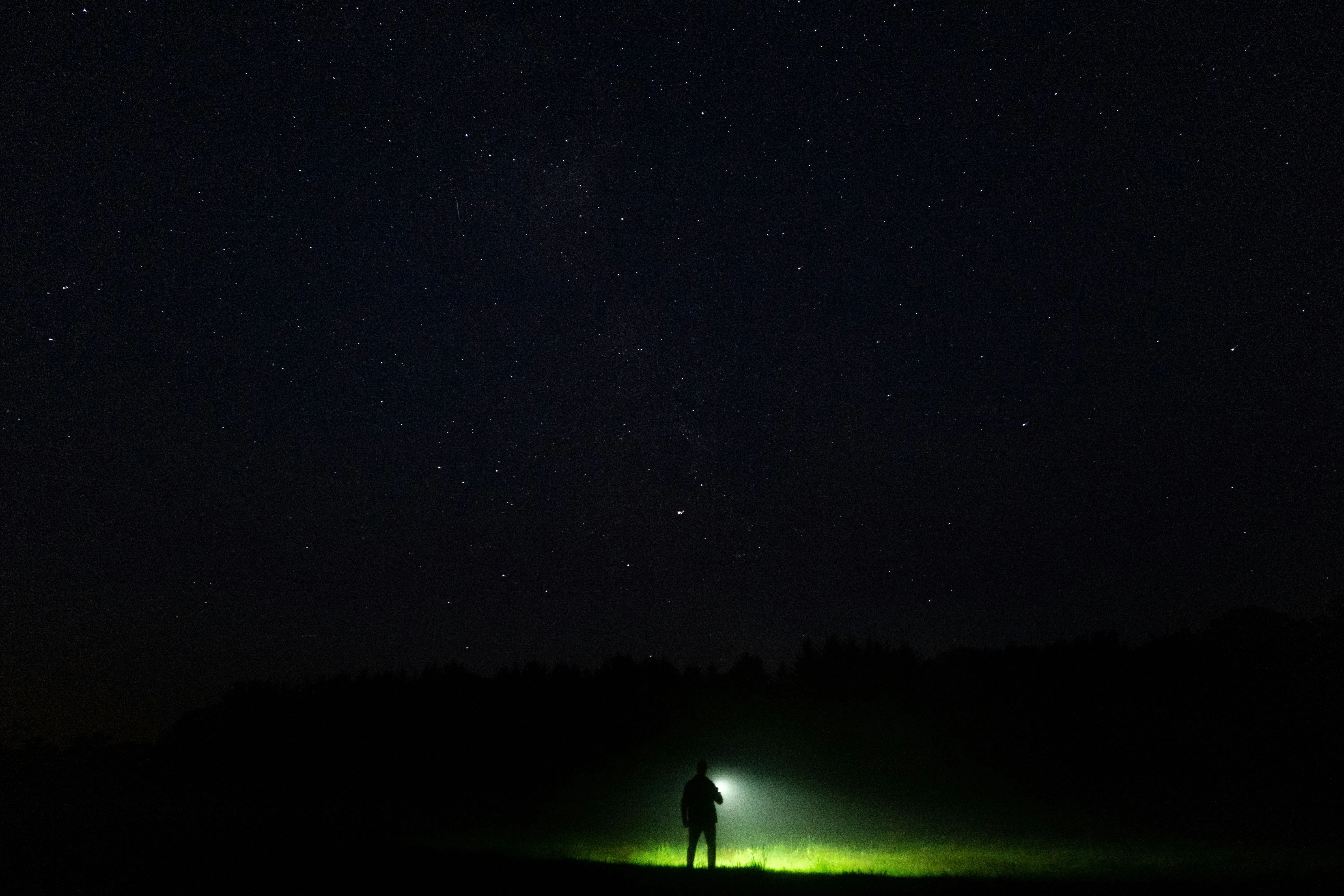 Night Sky with Lone Traveler Under Starry Light Wallpaper