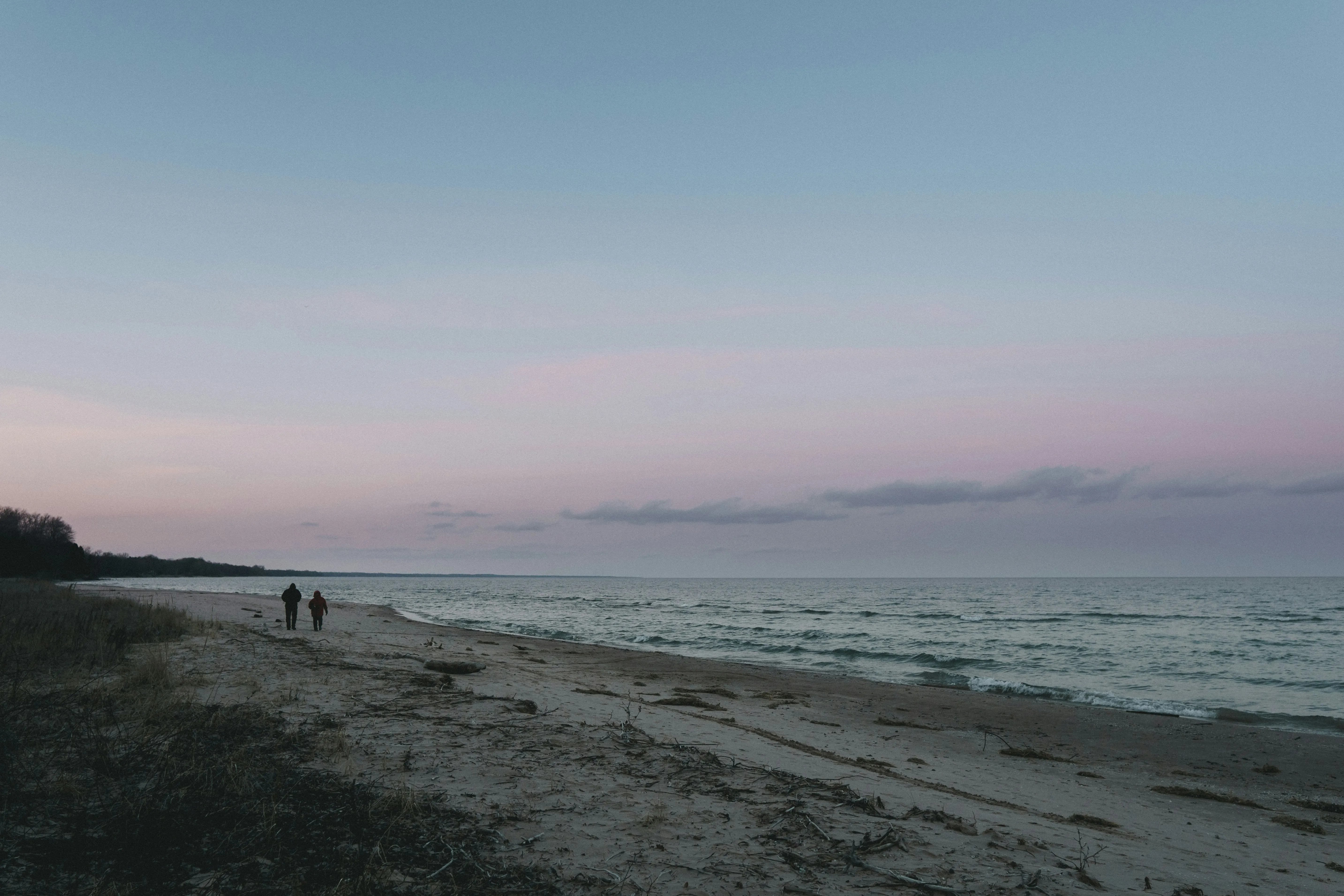 Peaceful Beach Sunset with Waves and Quiet Sky Wallpaper