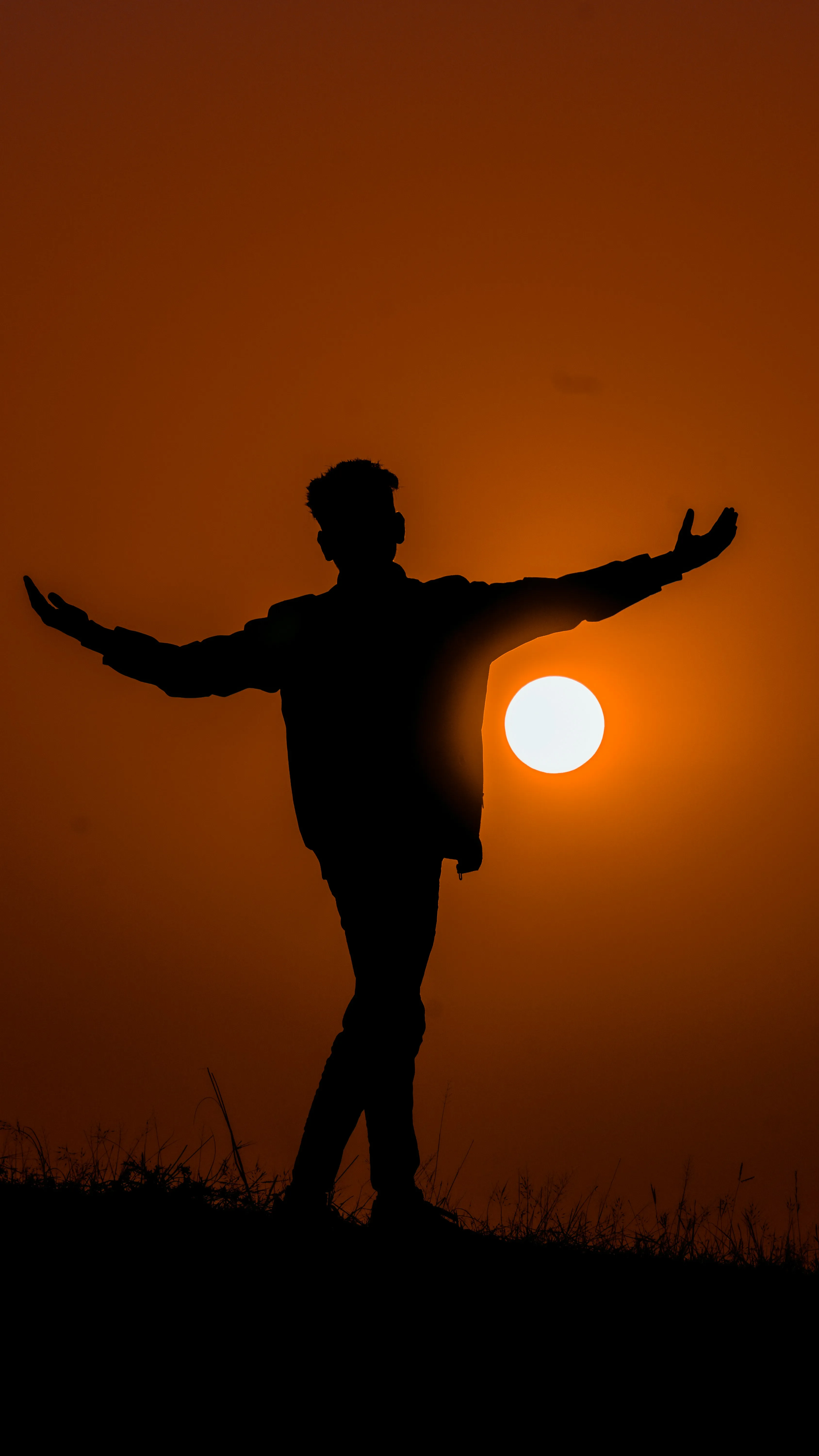 Person Posing with Arms Outstretched at Sunset Wallpaper