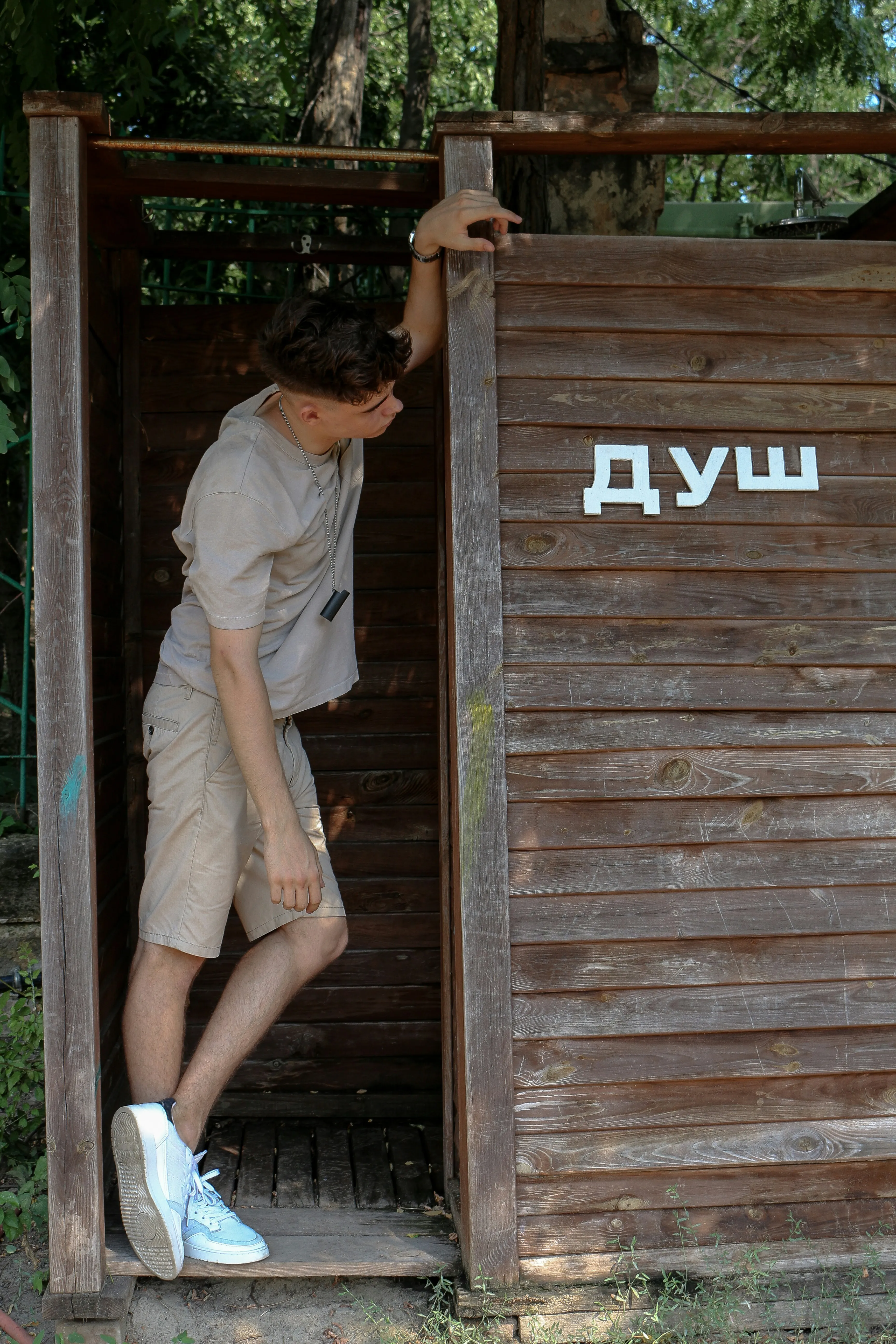 Person Standing by Rustic Wooden Outdoor Shower Wallpaper