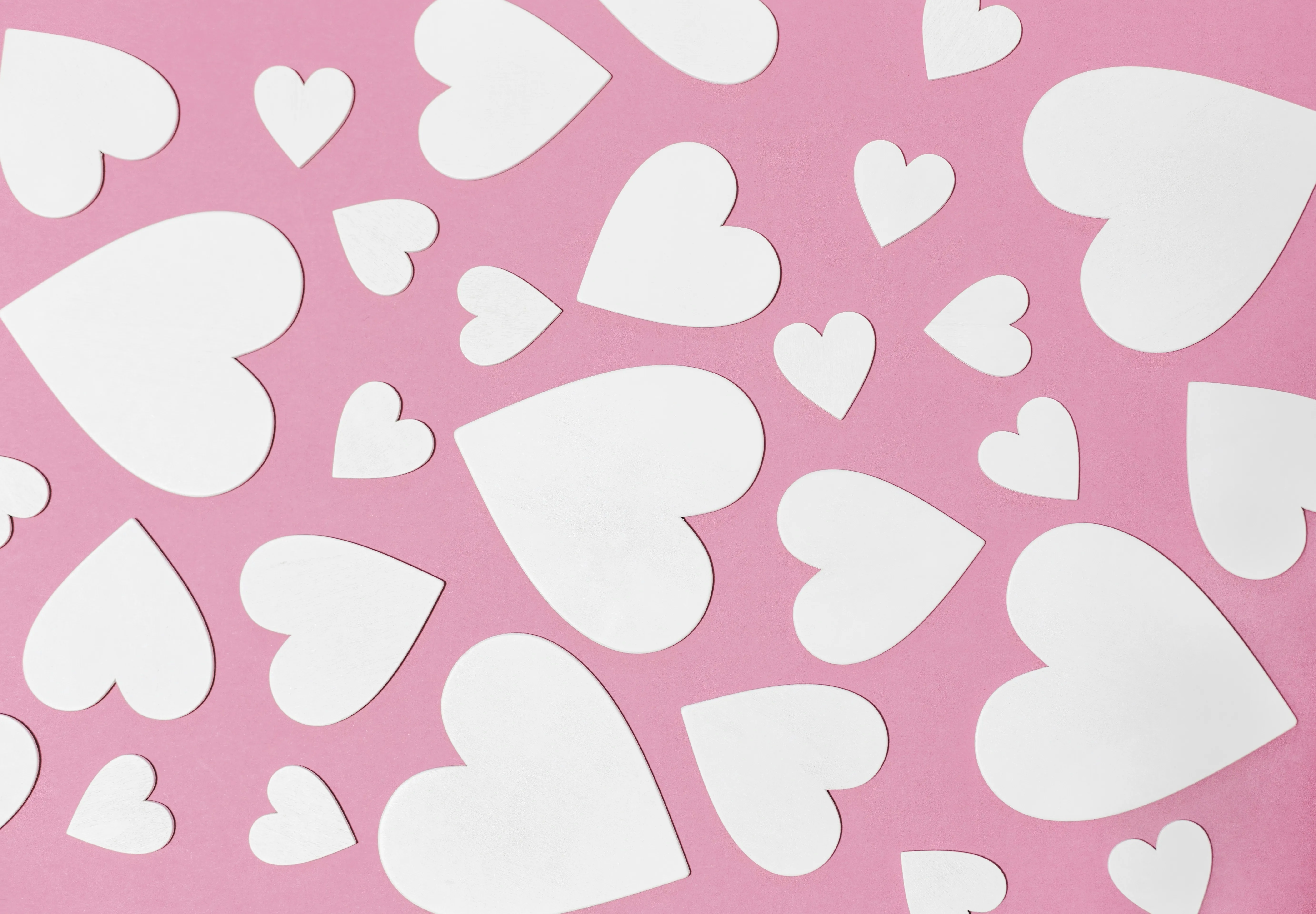 Pink Background Covered with White Heart Shapes Wallpaper