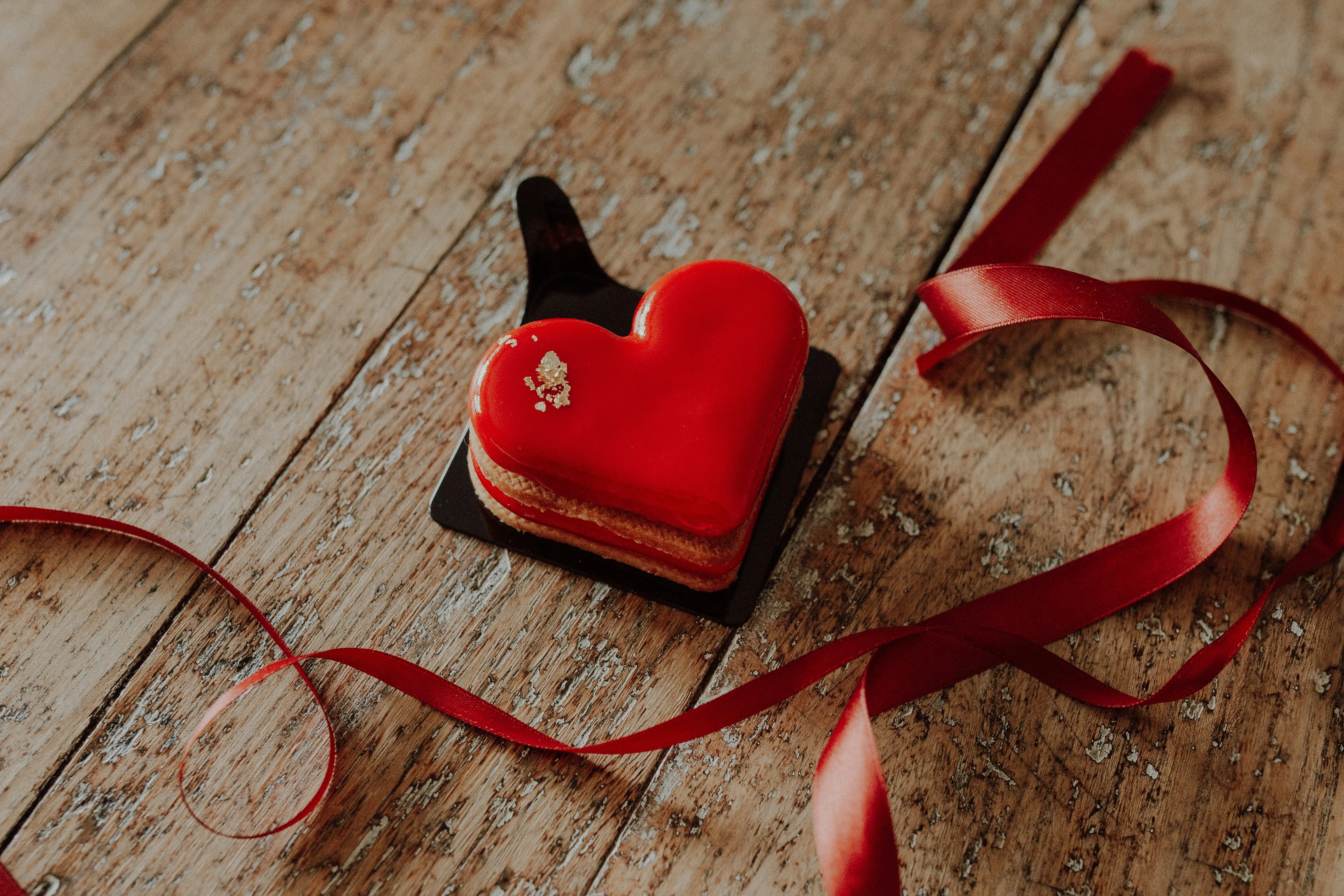 Red Heart Gift Box on Table Symbolizing Romance Wallpaper
