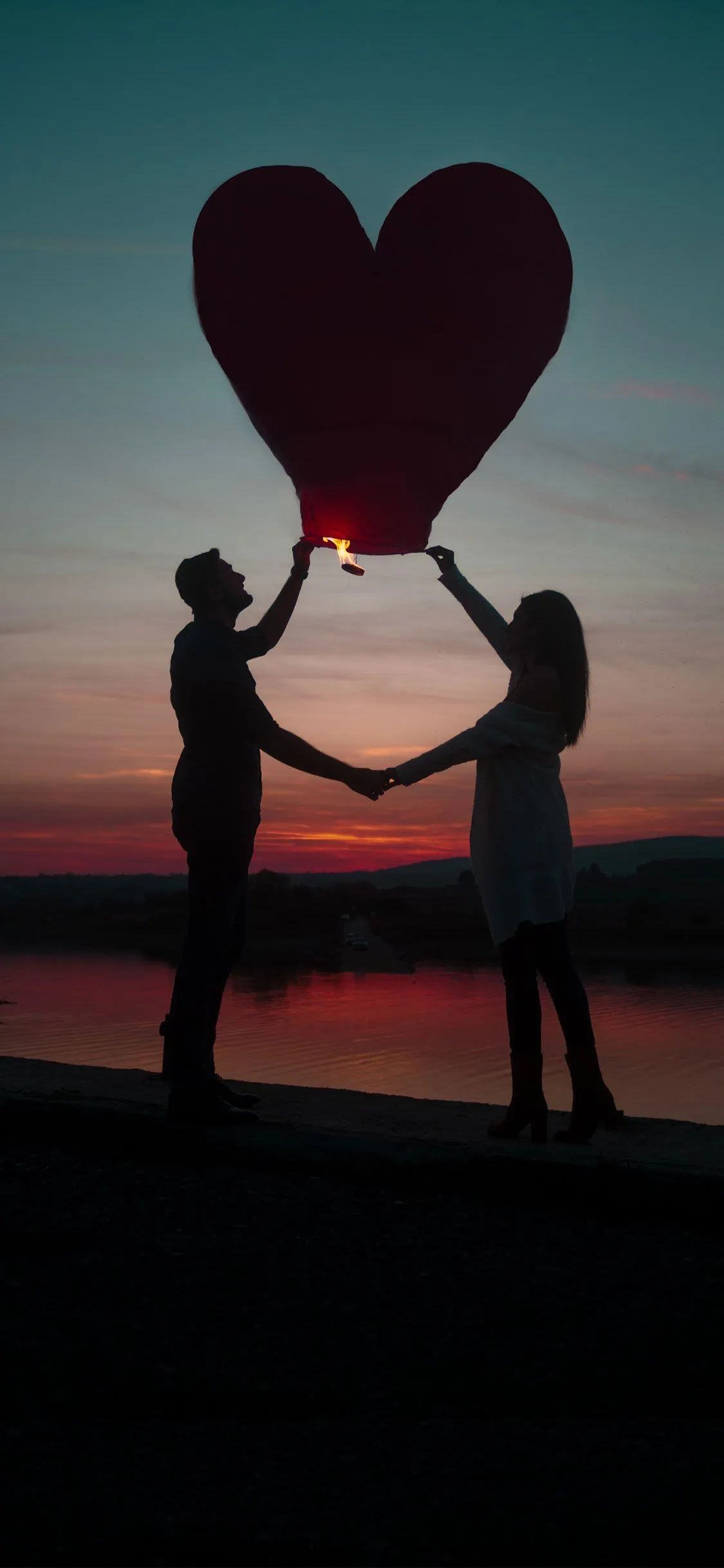 Romantic Couple Holding Heart Lantern at Sunset Moment