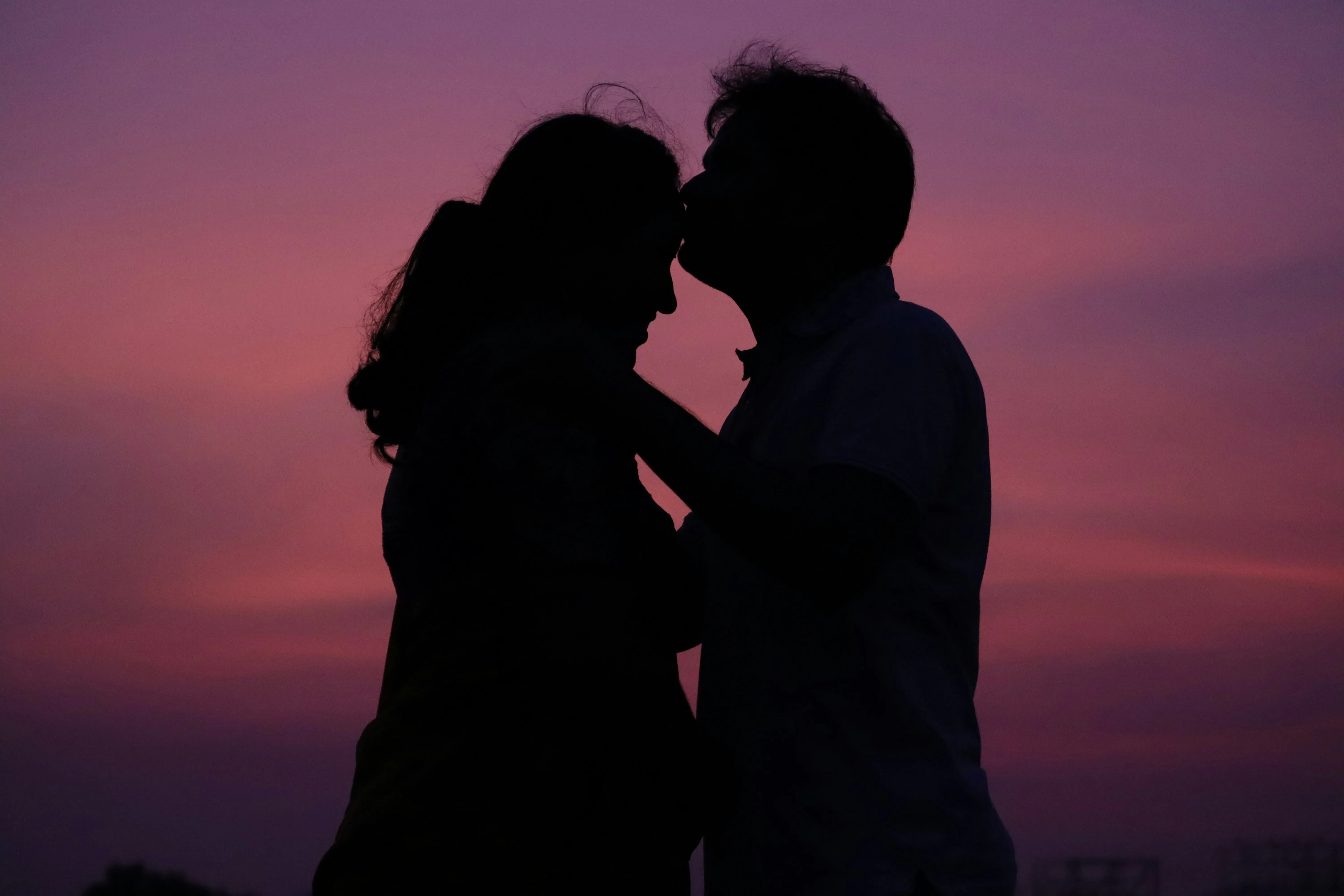 Romantic Couple Kissing During Sunset Moment Wallpaper