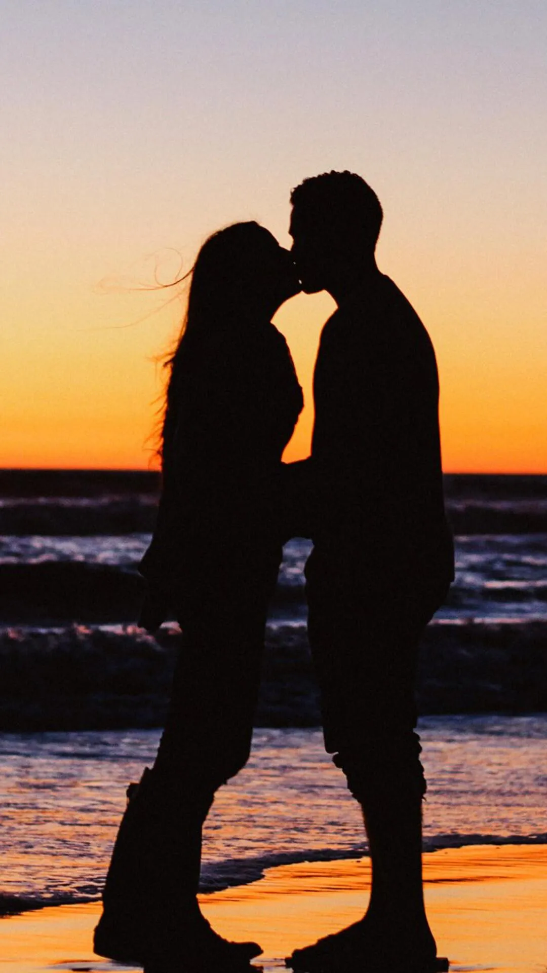 Romantic Couple Silhouette Standing at Beach Sunset