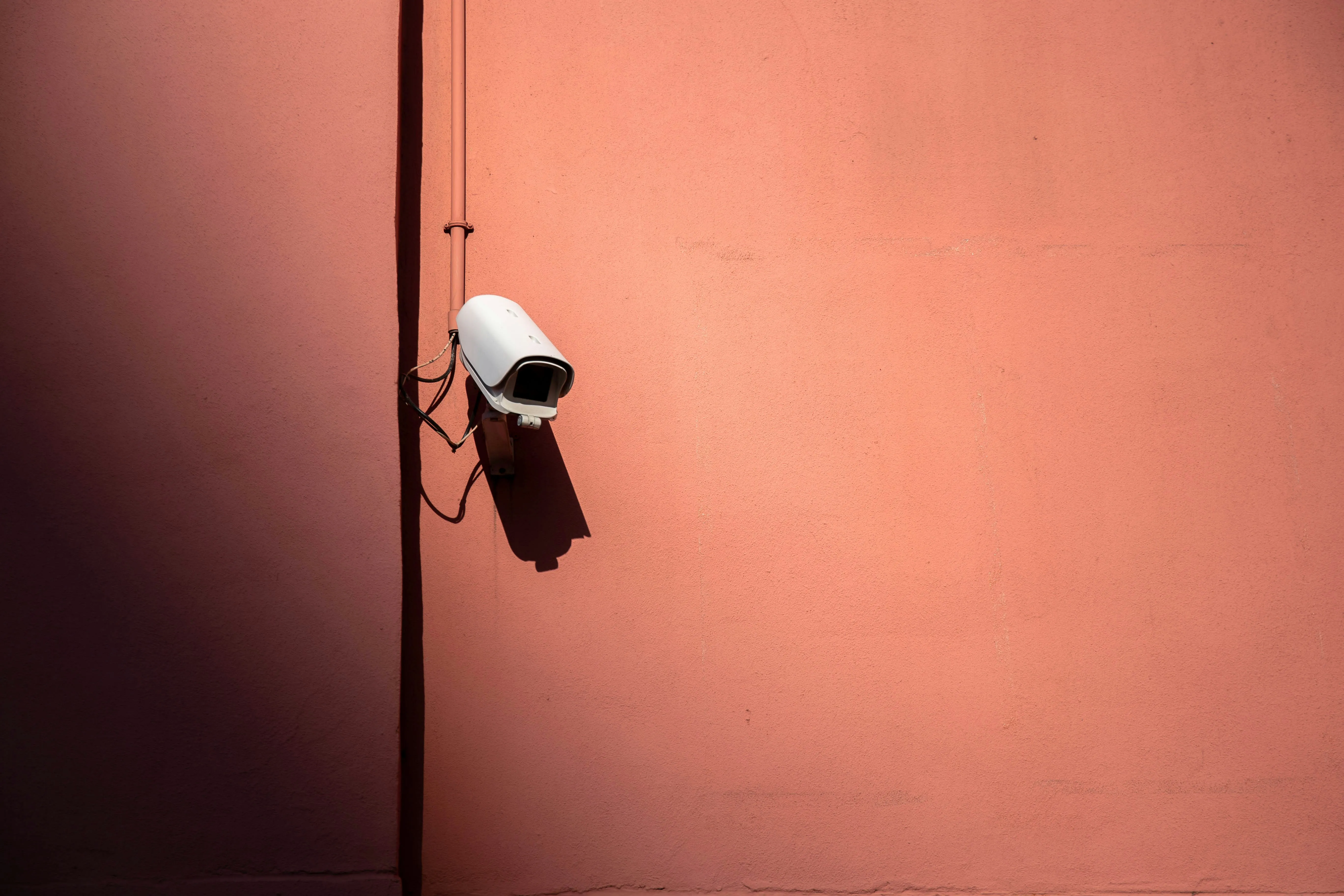 Security Camera Mounted on Minimal Peach Colored Wall
