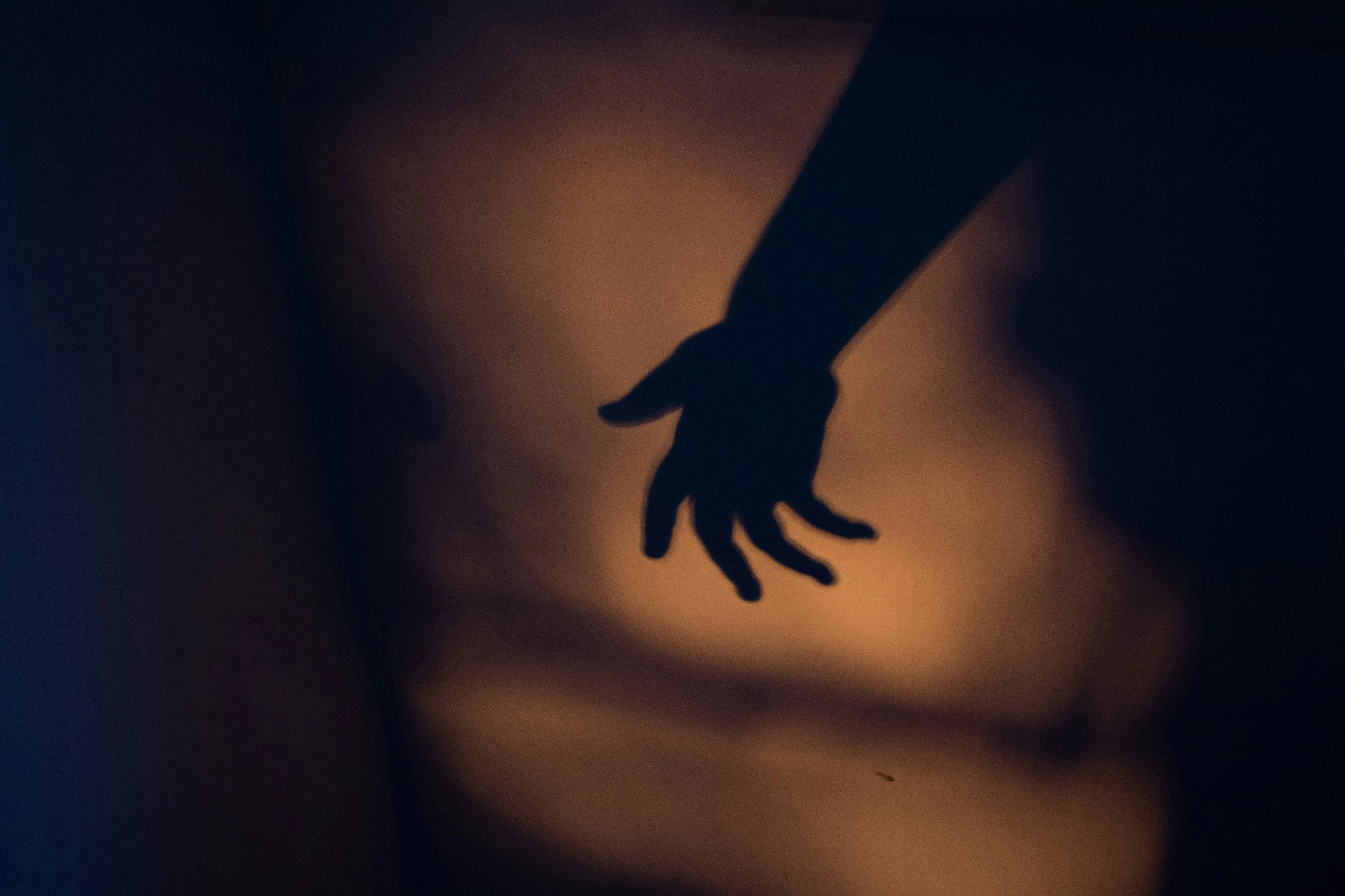 Shadow of Hand Reaching Out in Warm Golden Light Wallpaper