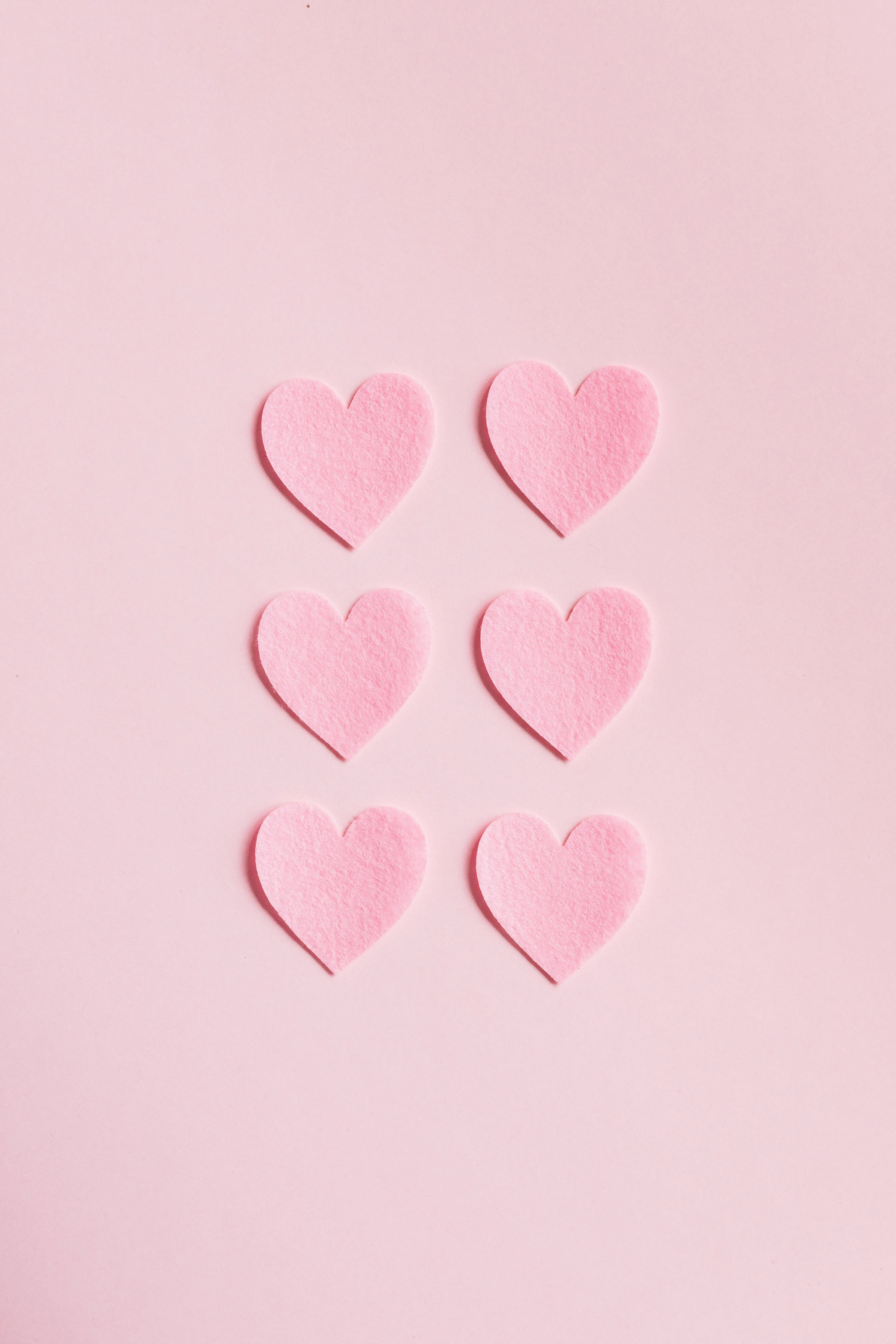 Soft Pink Background with Vertical Heart Shapes Wallpaper