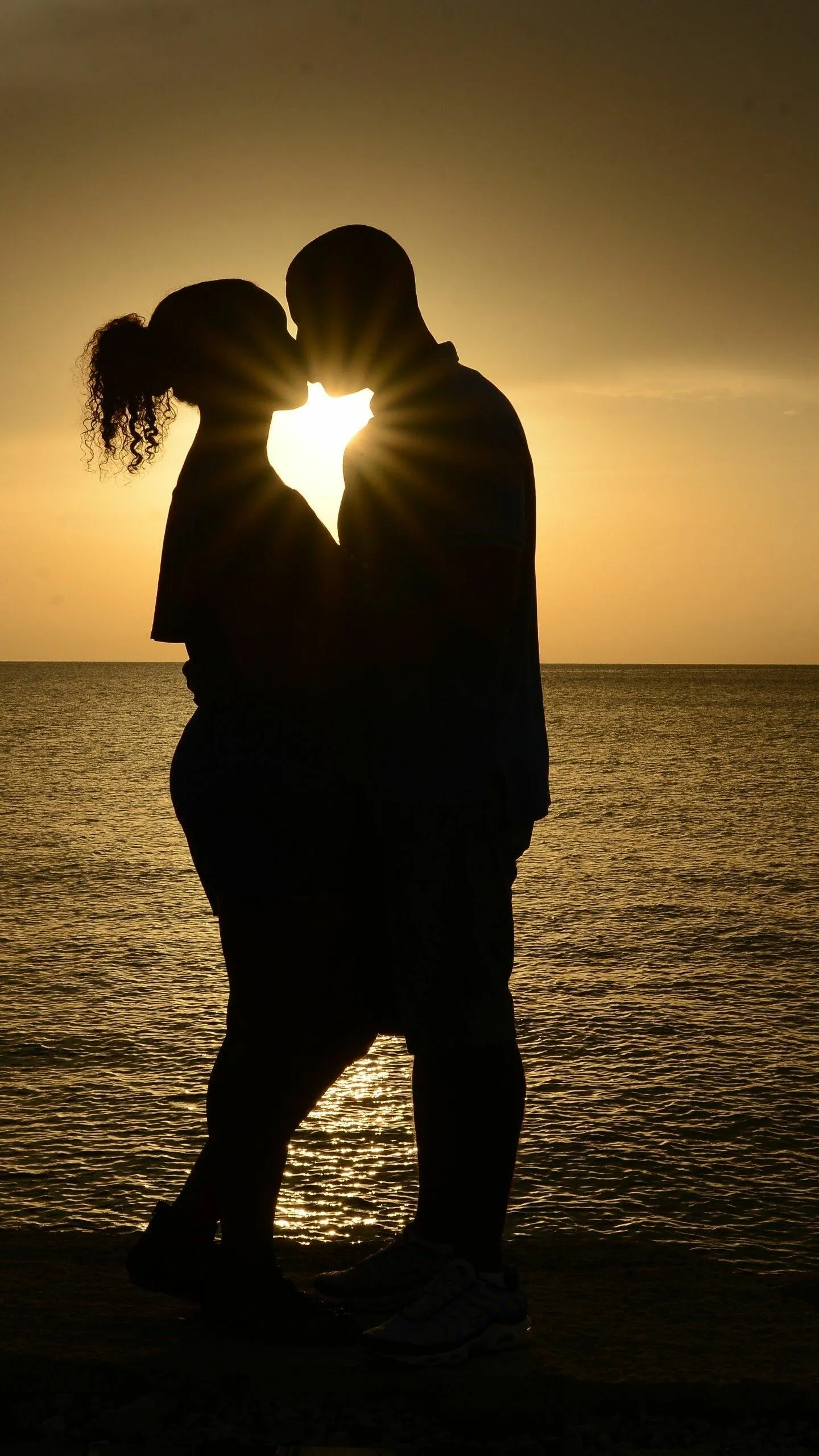 Sunset Silhouette Couple Embracing Eternal Romance Wallpaper