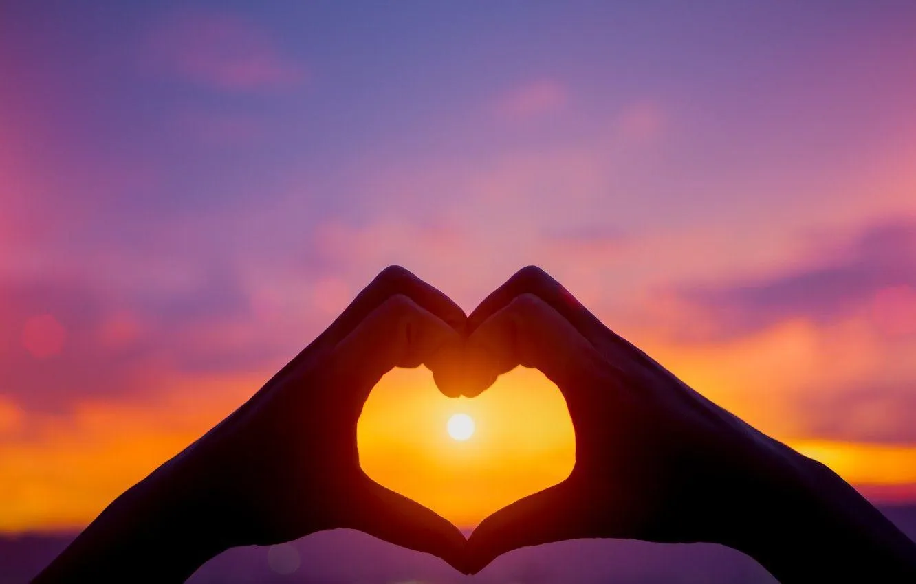 Sunset Silhouette Framing Heart with Hands of Love