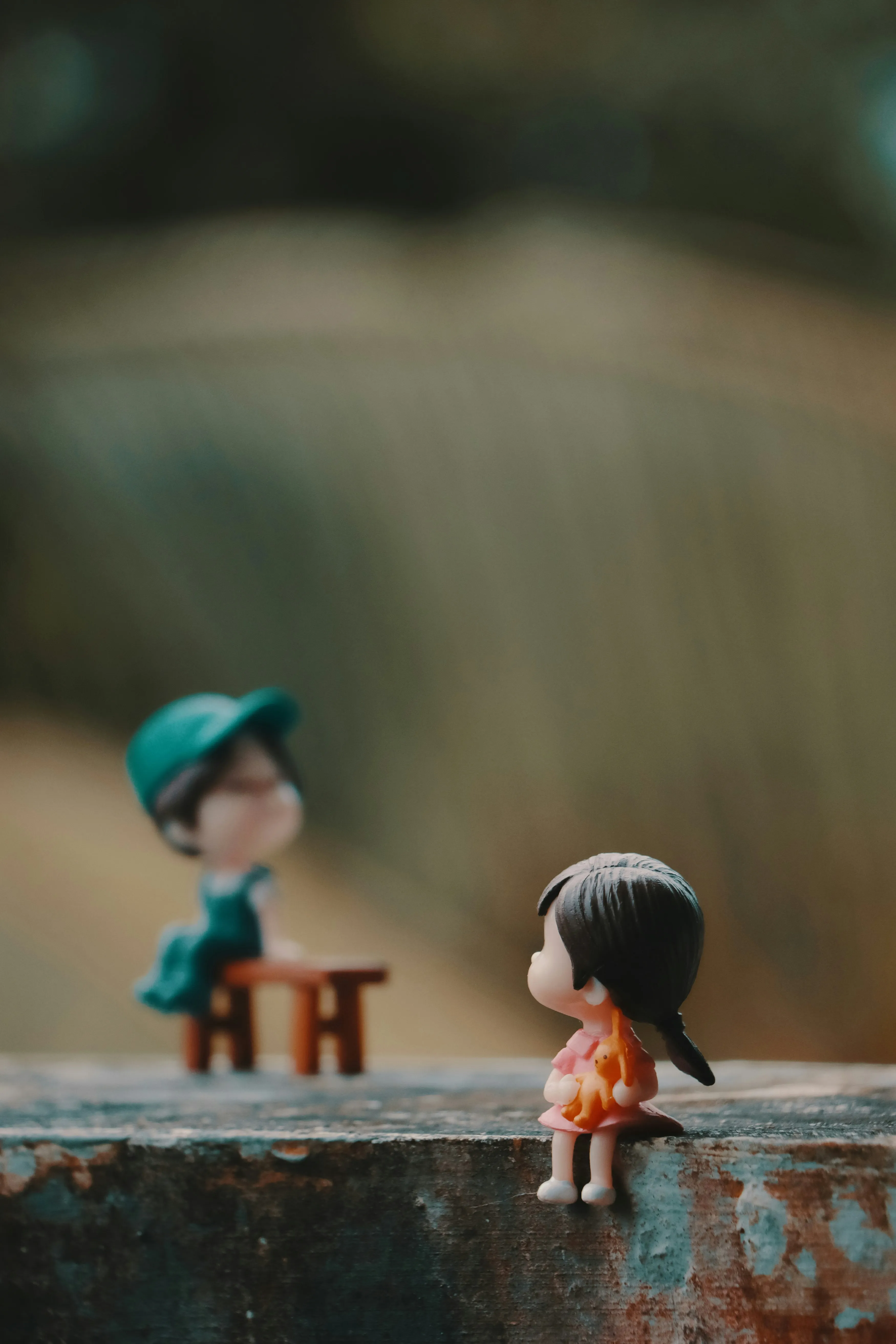 Toy Couple Sitting Together on Wooden Bench Wallpaper
