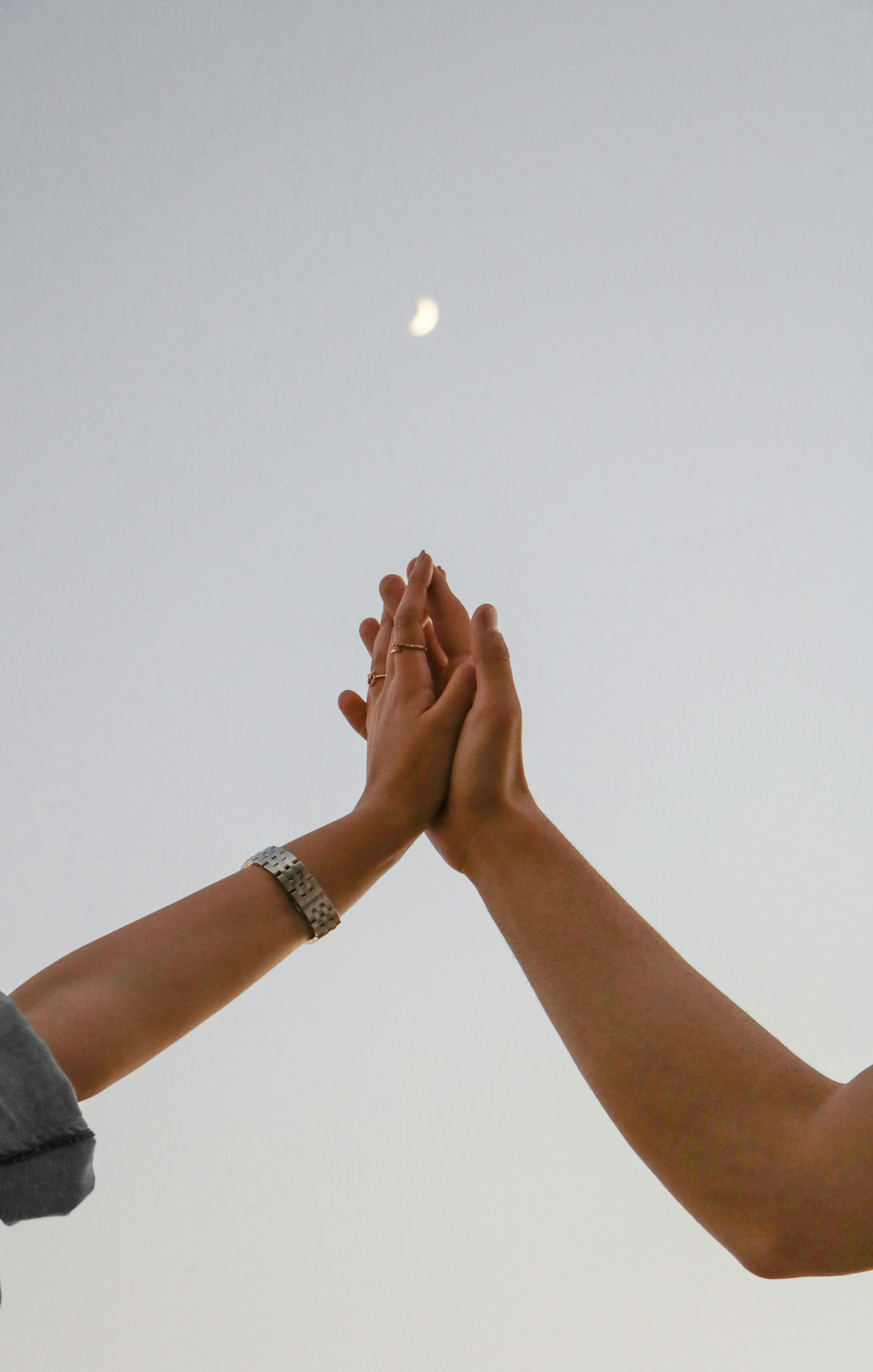 Two Hands Touching Gently Under Evening Sky Wallpaper