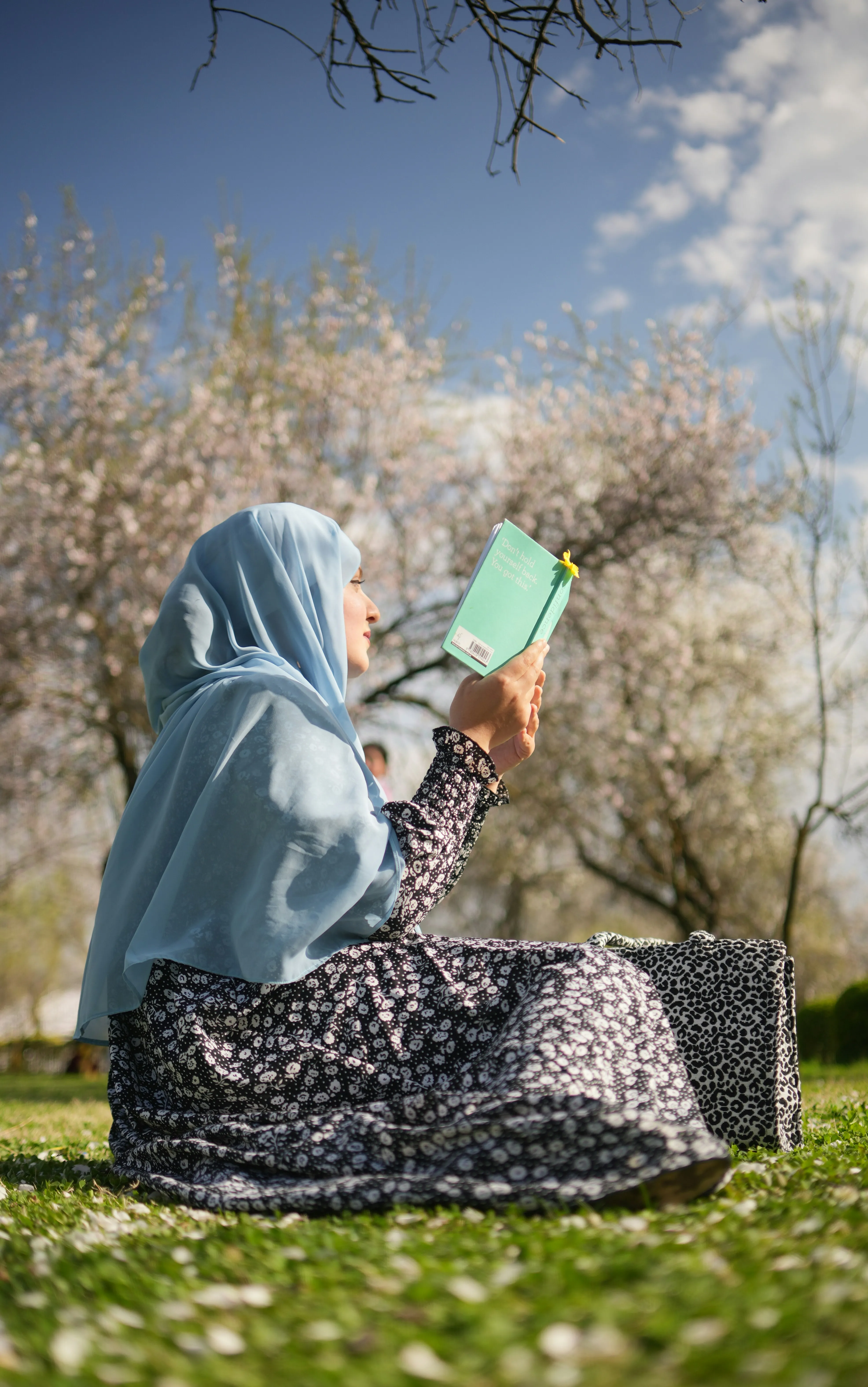 Woman Reading in Park Portrays Calm and Reflection Wallpaper