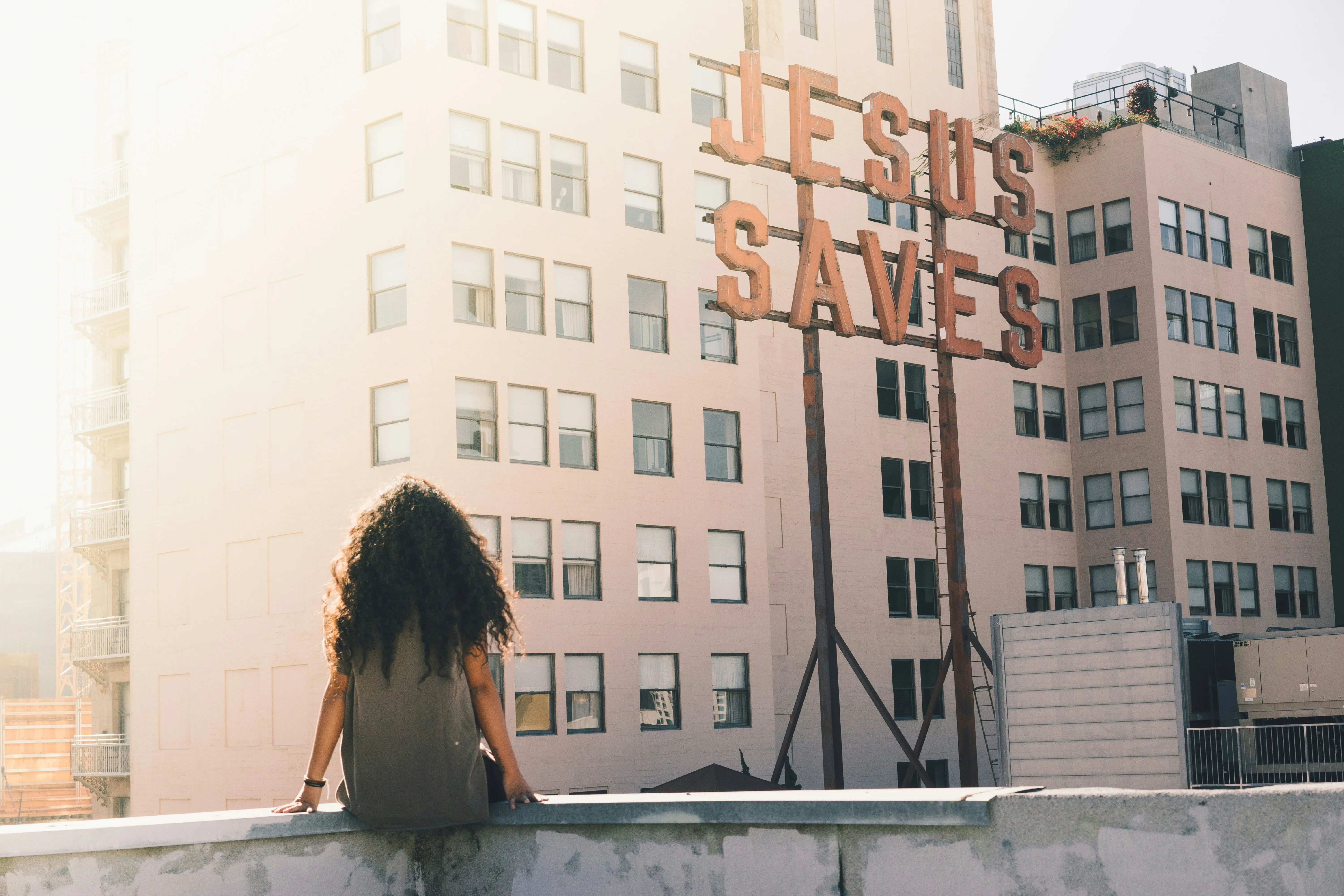 Woman Sitting Near Window in Warm City Light Wallpaper