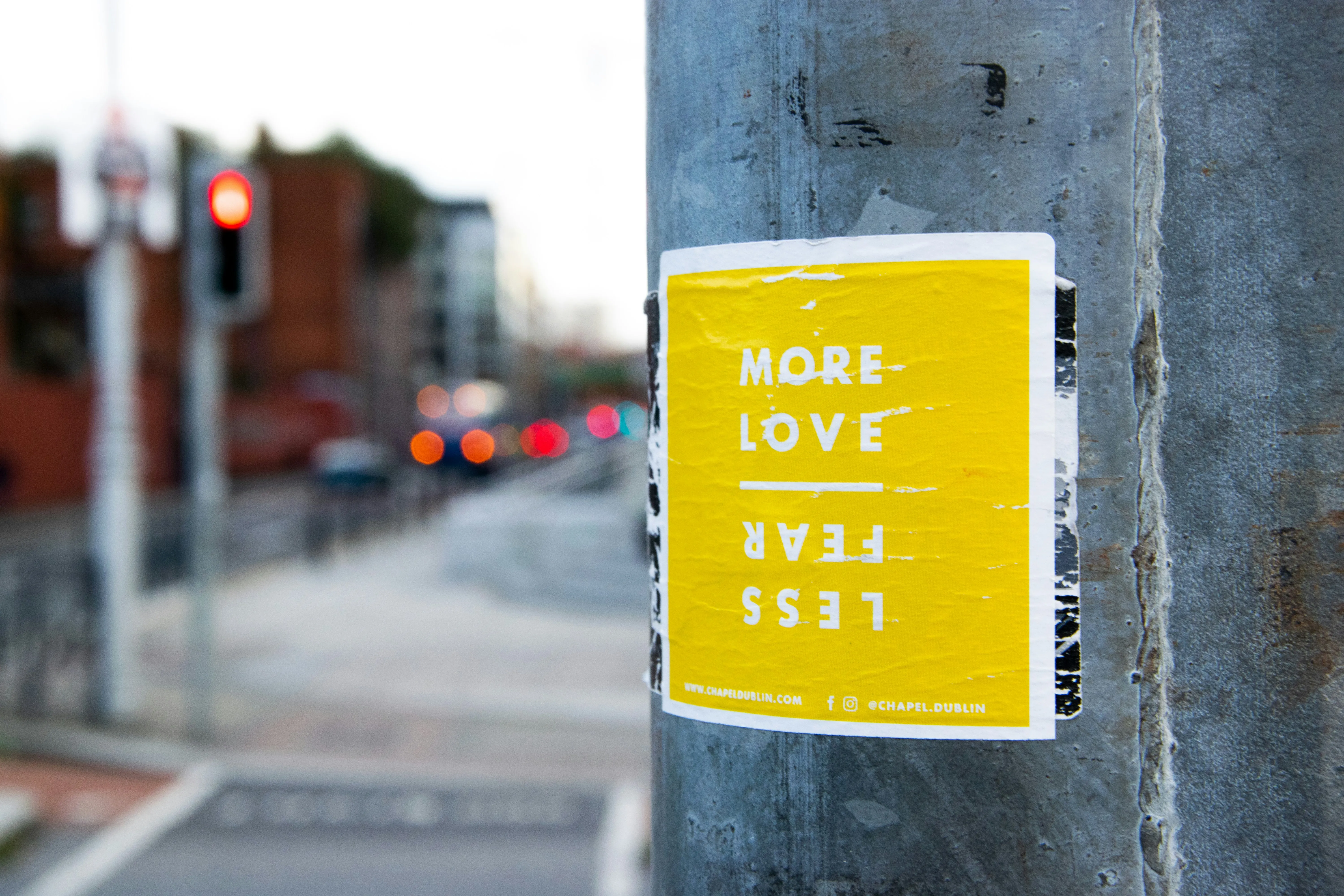 Yellow Sign Promoting More Love on City Street Wallpaper