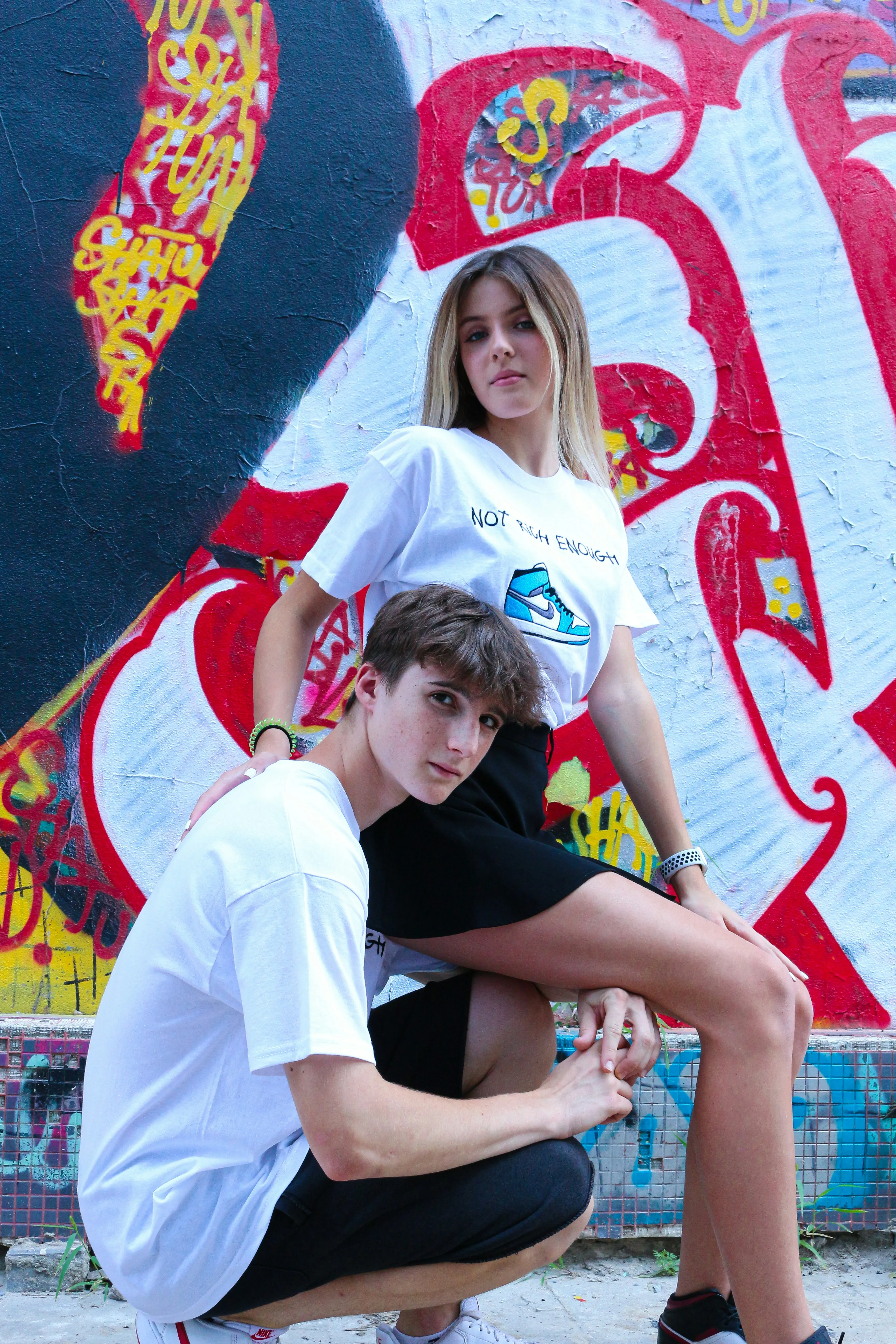 Young Couple Sitting Against Vibrant Wall Art Wallpaper