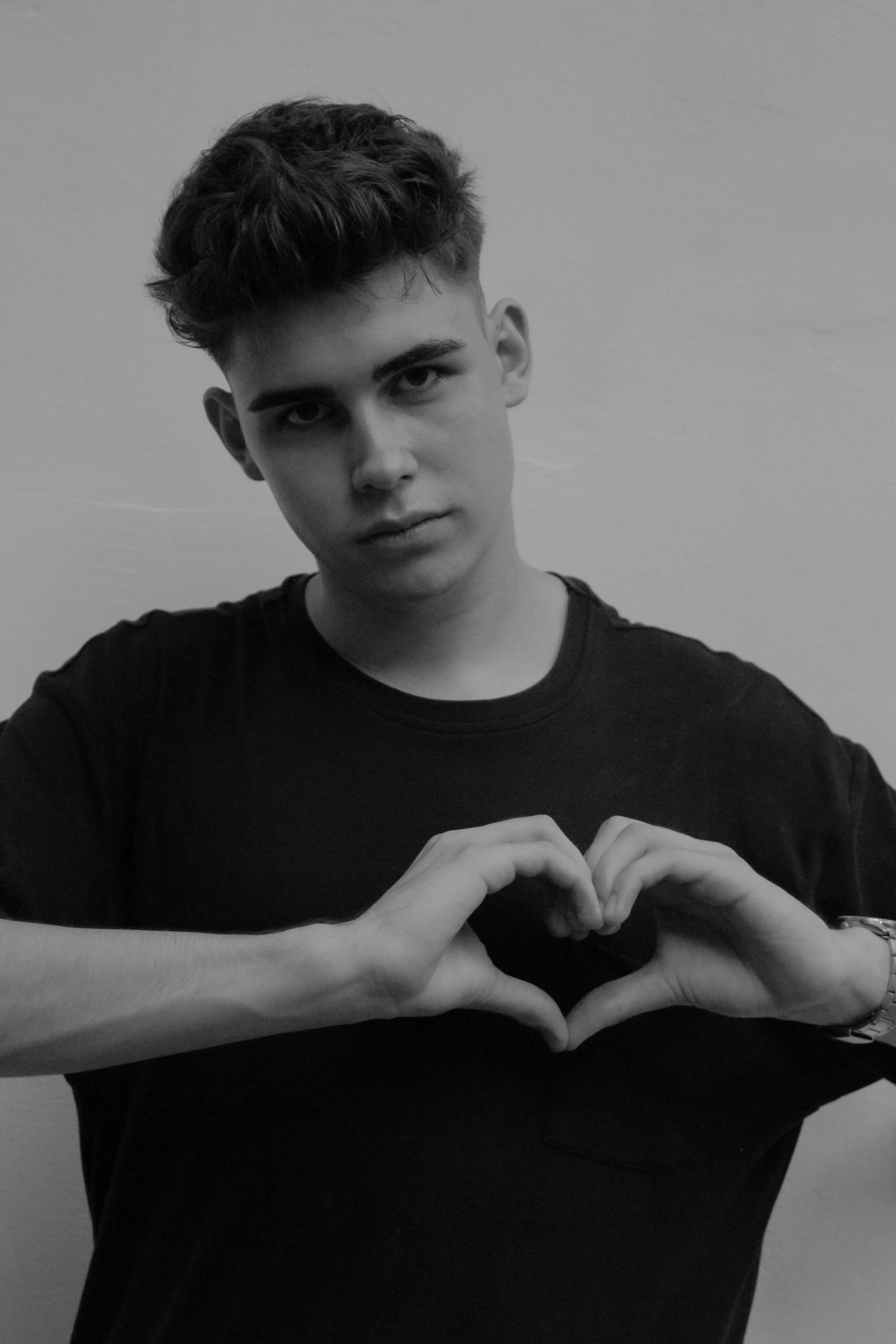 Young Man Making Heart Gesture with Hands Wallpaper