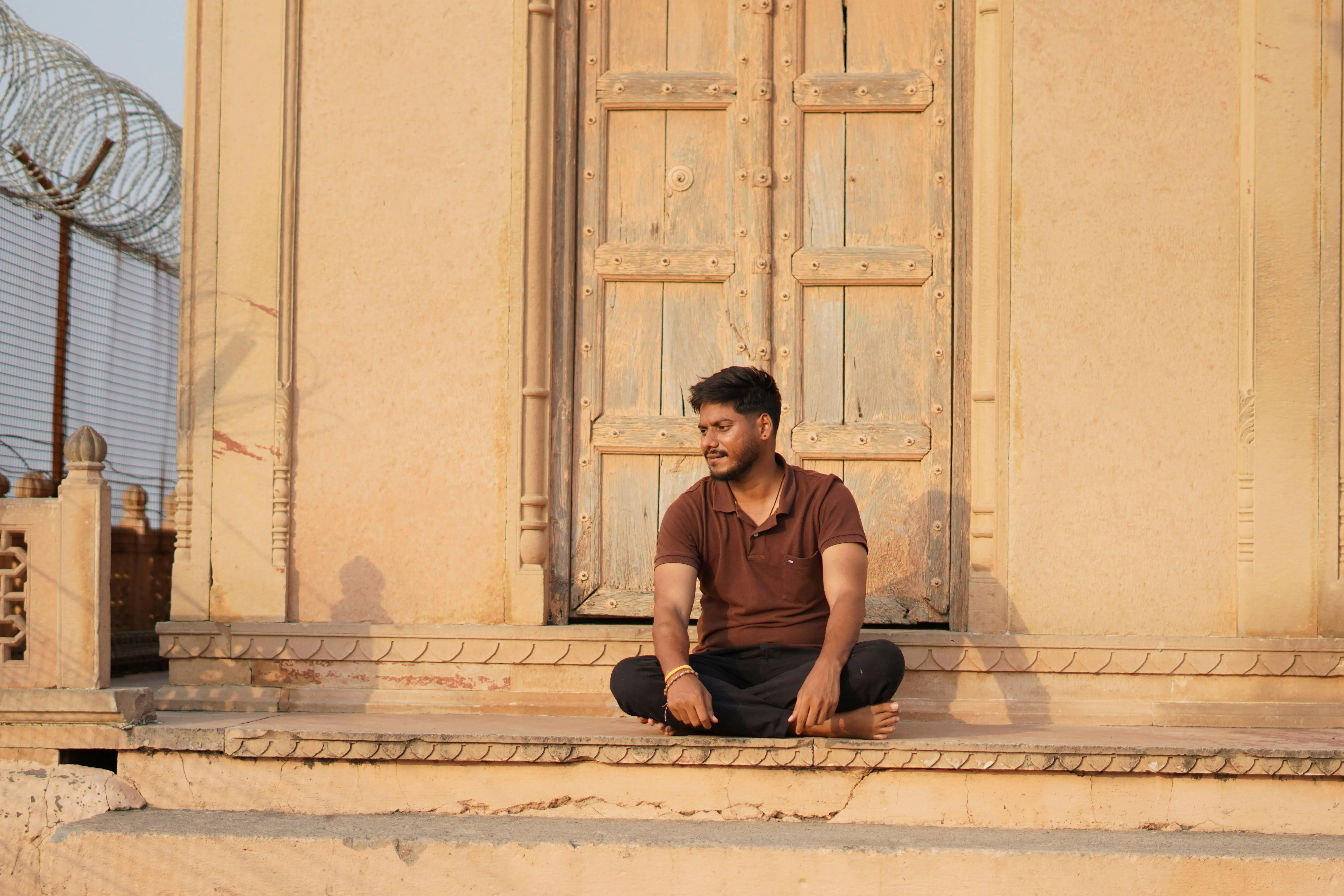 Young Man Sitting on Steps in Thoughtful Silence Wallpaper