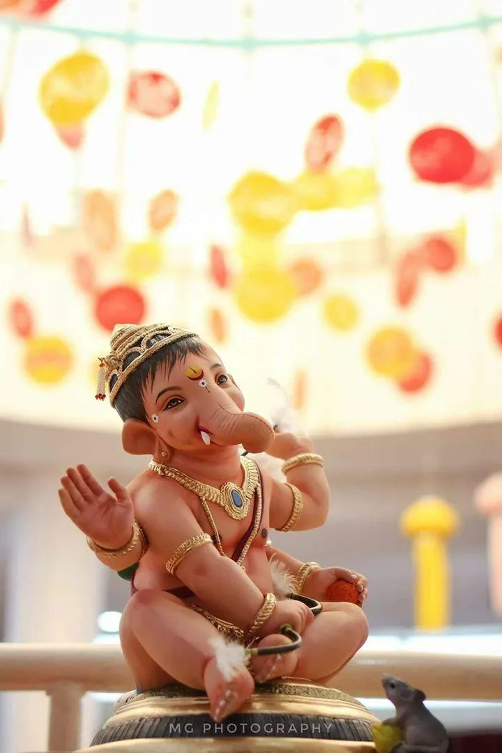 Cute Baby Ganesh Sitting with Playful Smile Pose Wallpaper