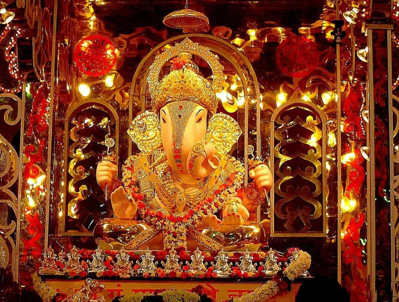 Golden Ganesh Idol with Lights in Temple Setting Wallpaper