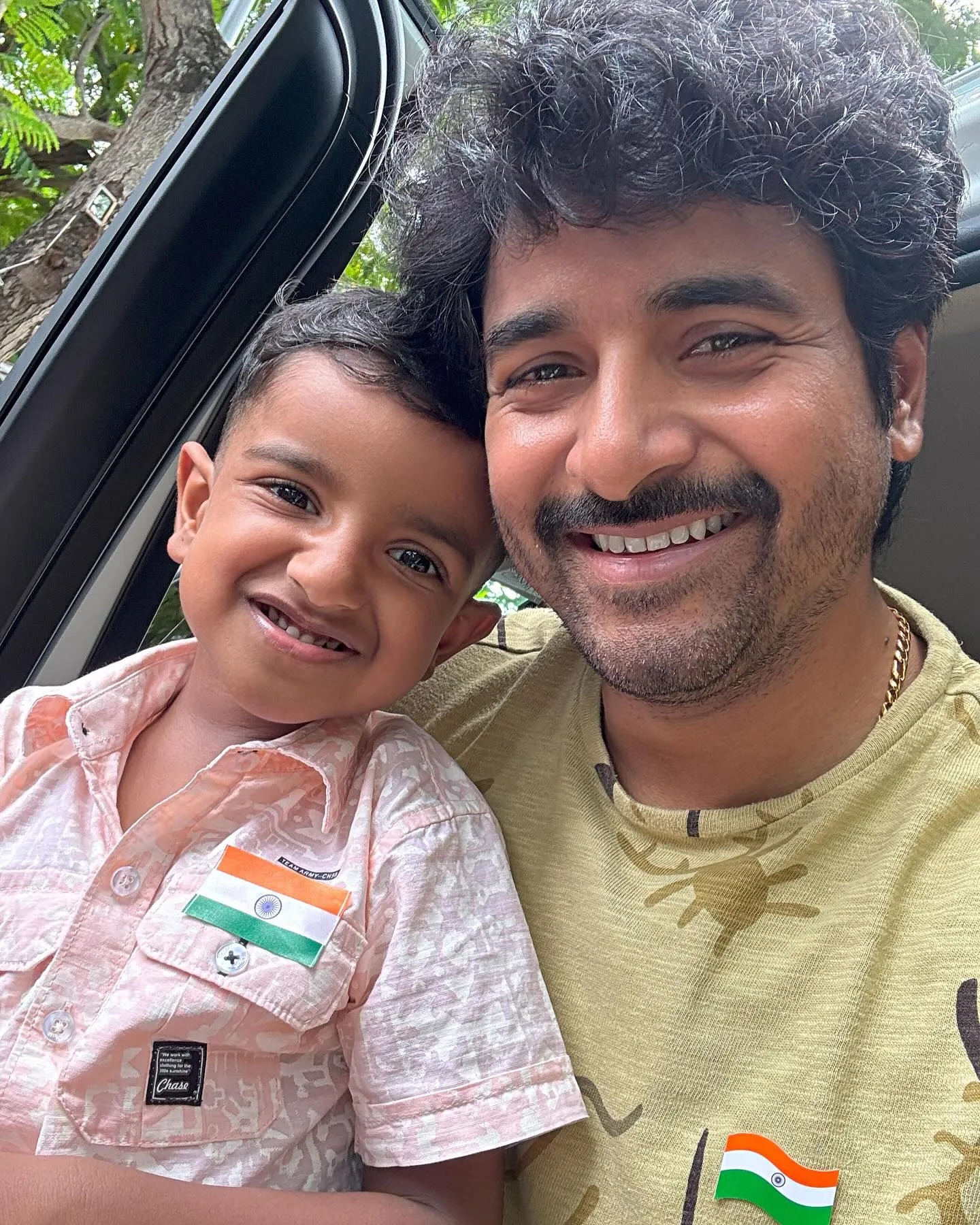 Cute Wallpaper of Sivakarthikeyan Taking Pics with Son Gugan