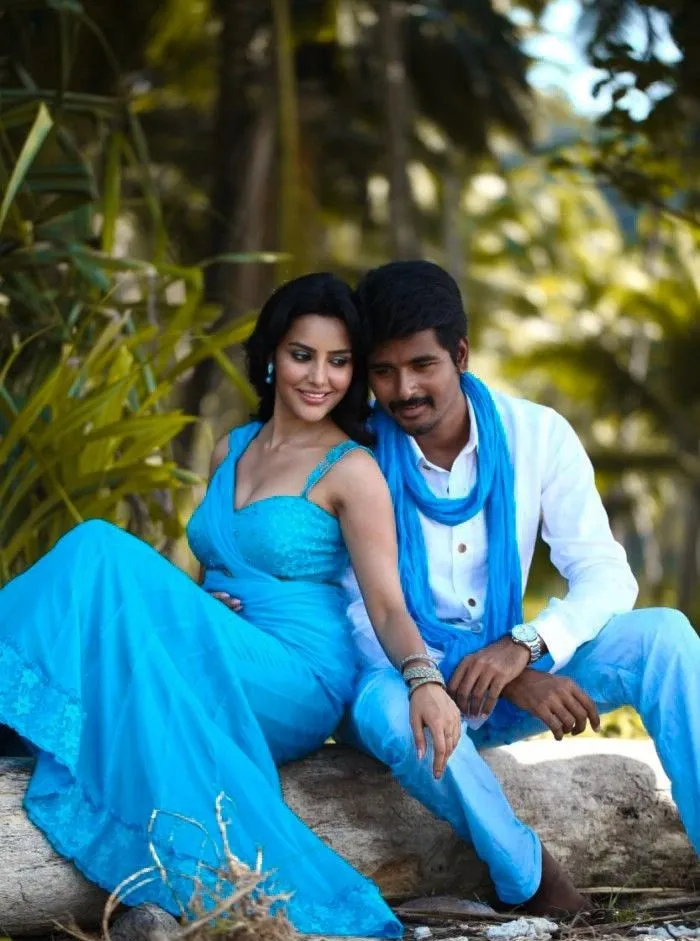 Sivakarthikeyan and Priya Anand in Blue Sitting on a Wood