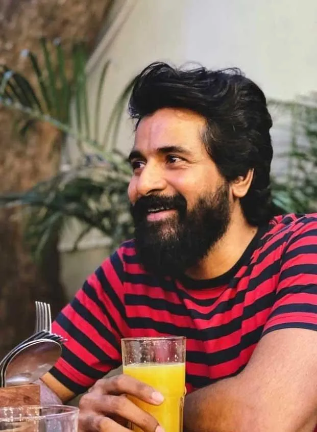 Sivakarthikeyan Holding Drink and Smiling To Right Side