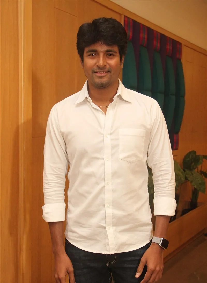 Sivakarthikeyan in a White Shirt with Orange Wall Background