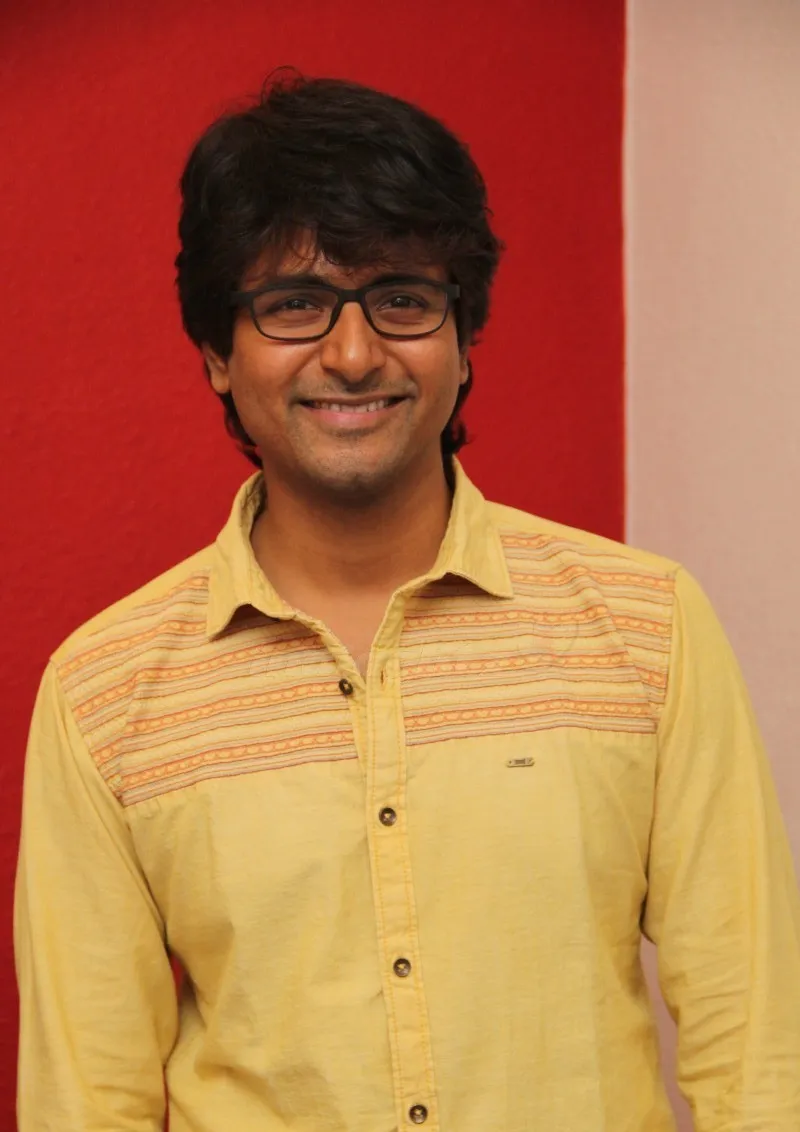 Sivakarthikeyan in a Yellow Shirt Smiling Against the Camera