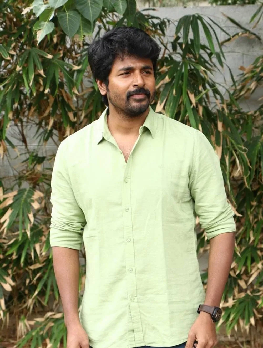 Sivakarthikeyan in Green Shirt Standing Near the Plants