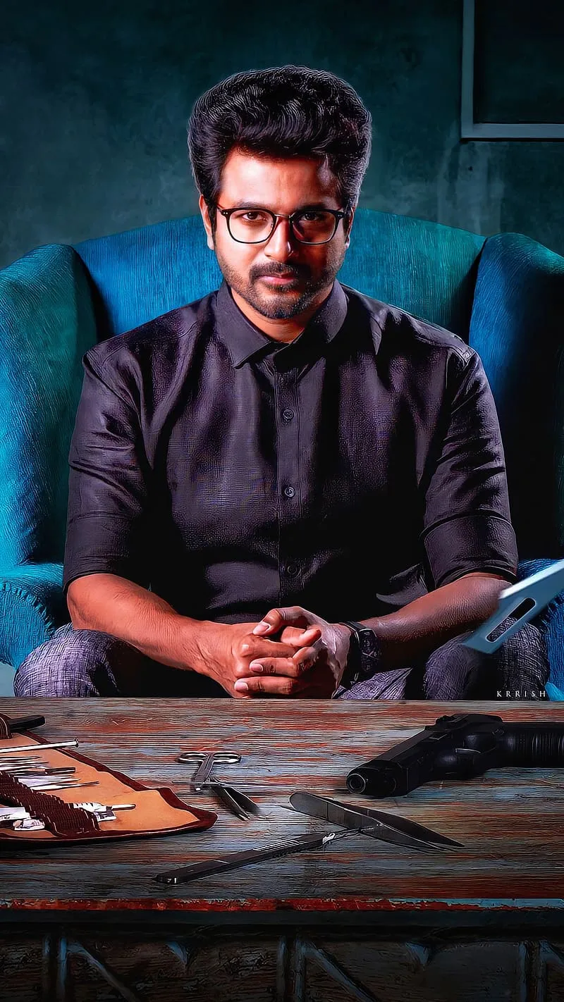 Sivakarthikeyan Sitting At Desk with Papers with Serious Face